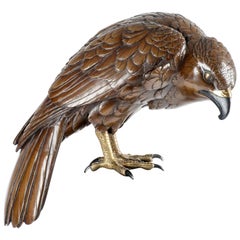 A Japanese bronze sculpture depicting a falcon, signed by Kōmin