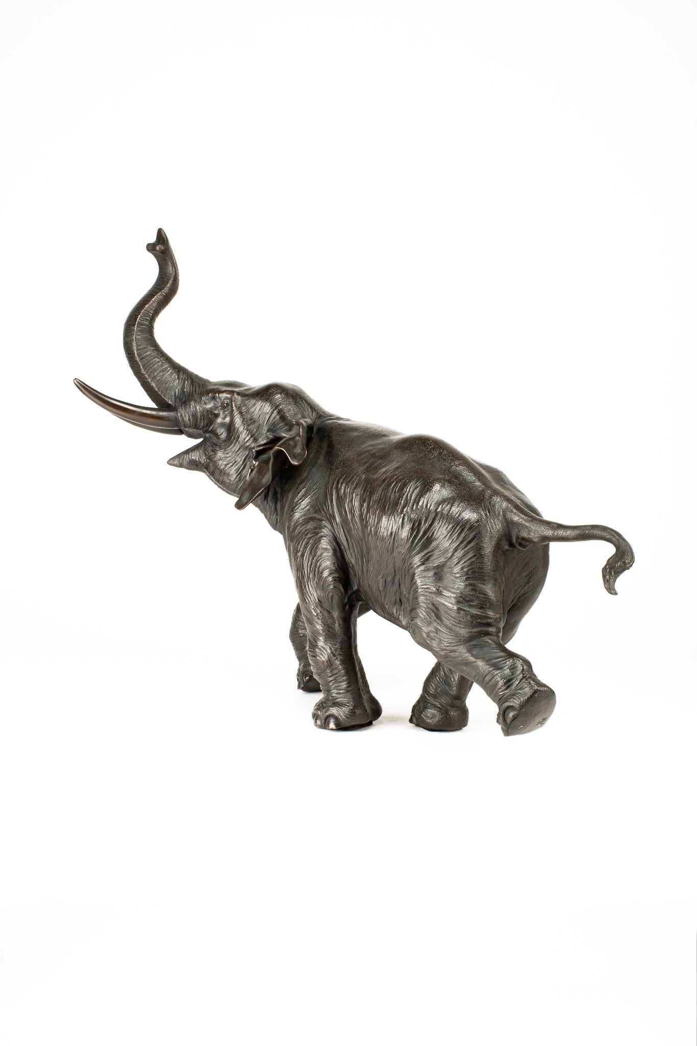 19th Century A Japanese bronze sculpture depicting a running elephant with its raised trunk