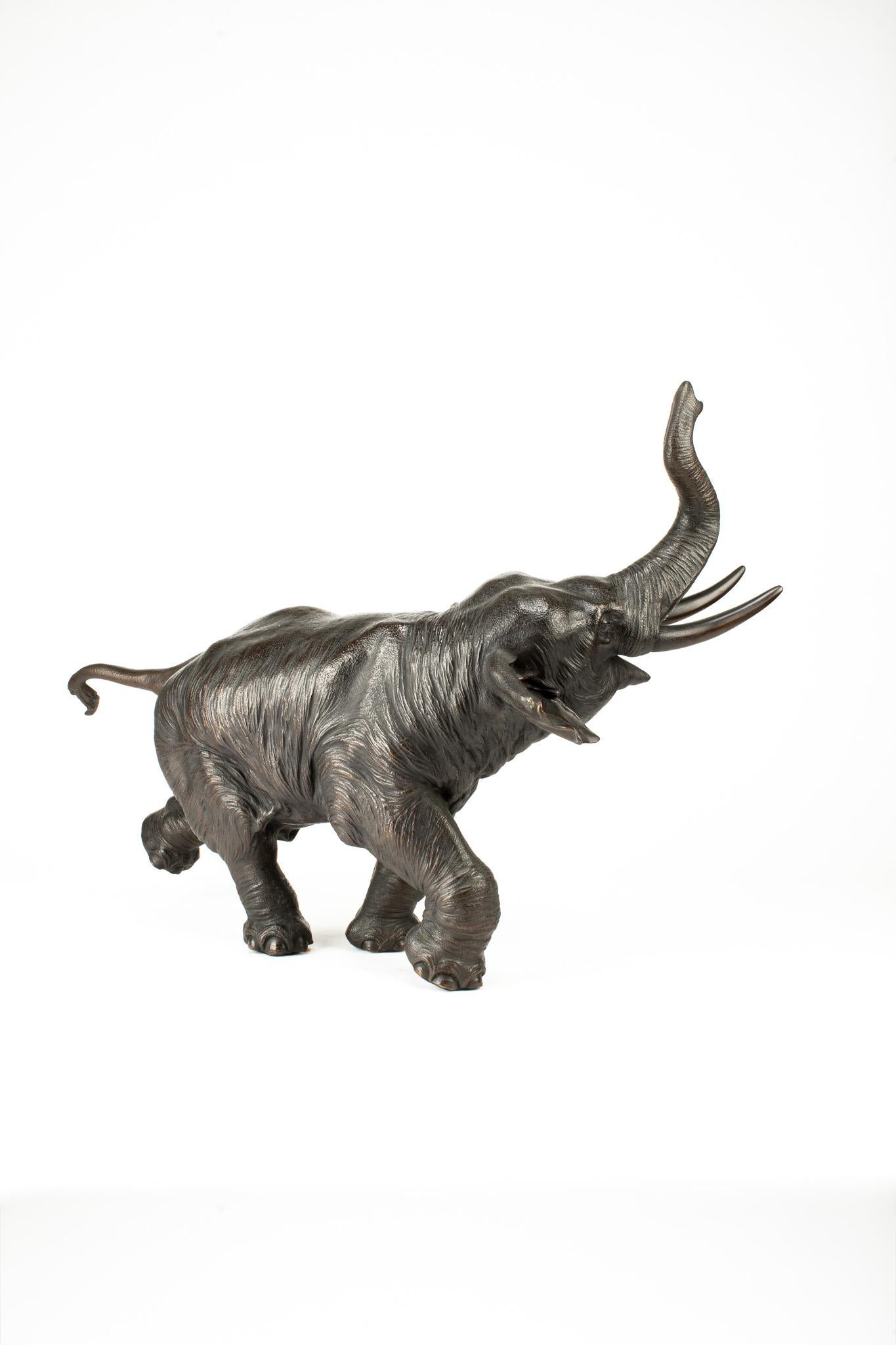 A Japanese bronze sculpture depicting a running elephant with its raised trunk 2