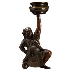 A Japanese bronze sculpture depicting an oni with a ceremonial kōro