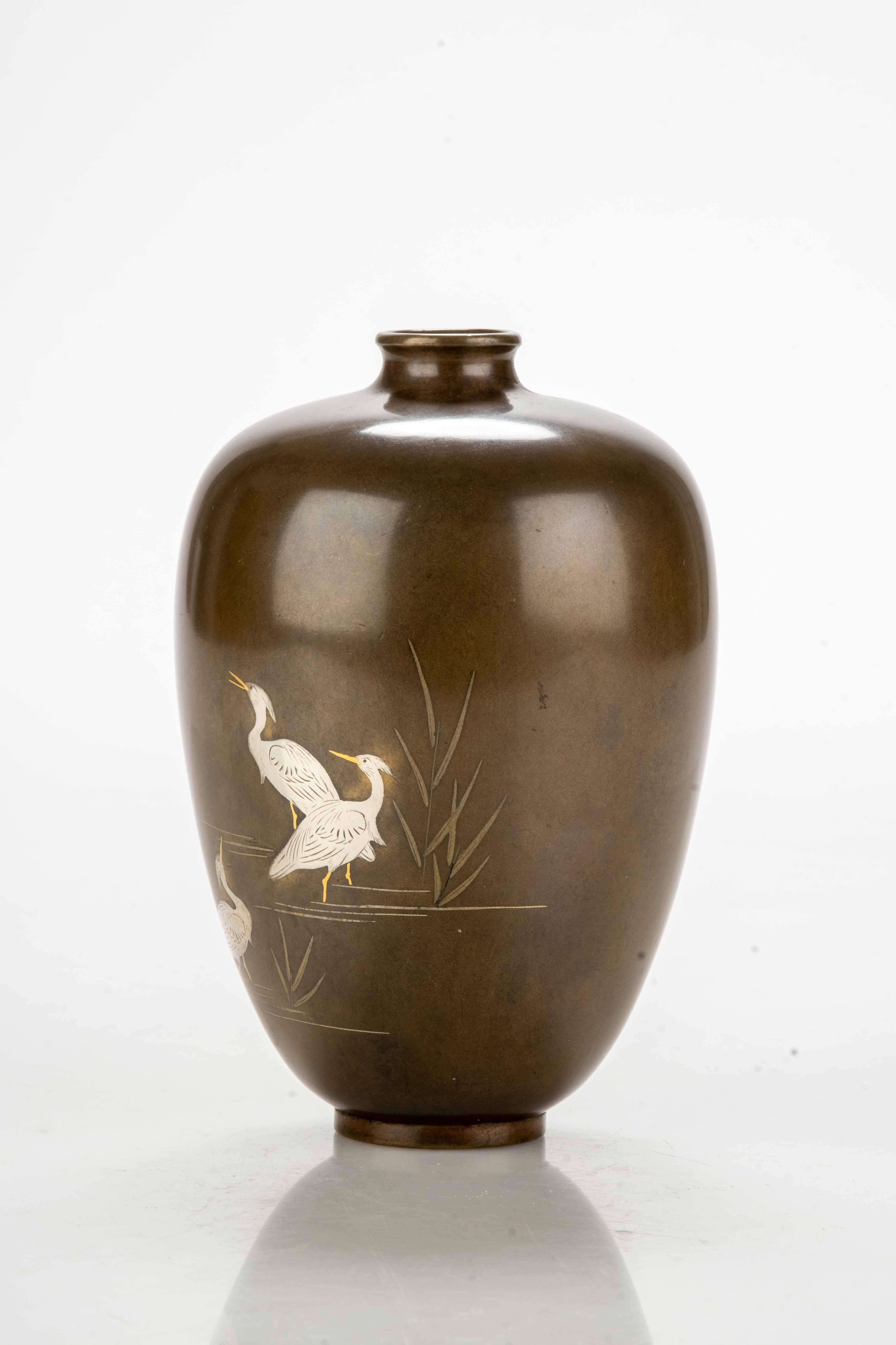 Bulbous vase in bronze with a shiny patina and three elegant white egrets in inlaid silver with golden beaks and feet.

Period: Meiji, late 19th century.
Dimensions: 11 x 8.5 cm.
Condition: Excellent.