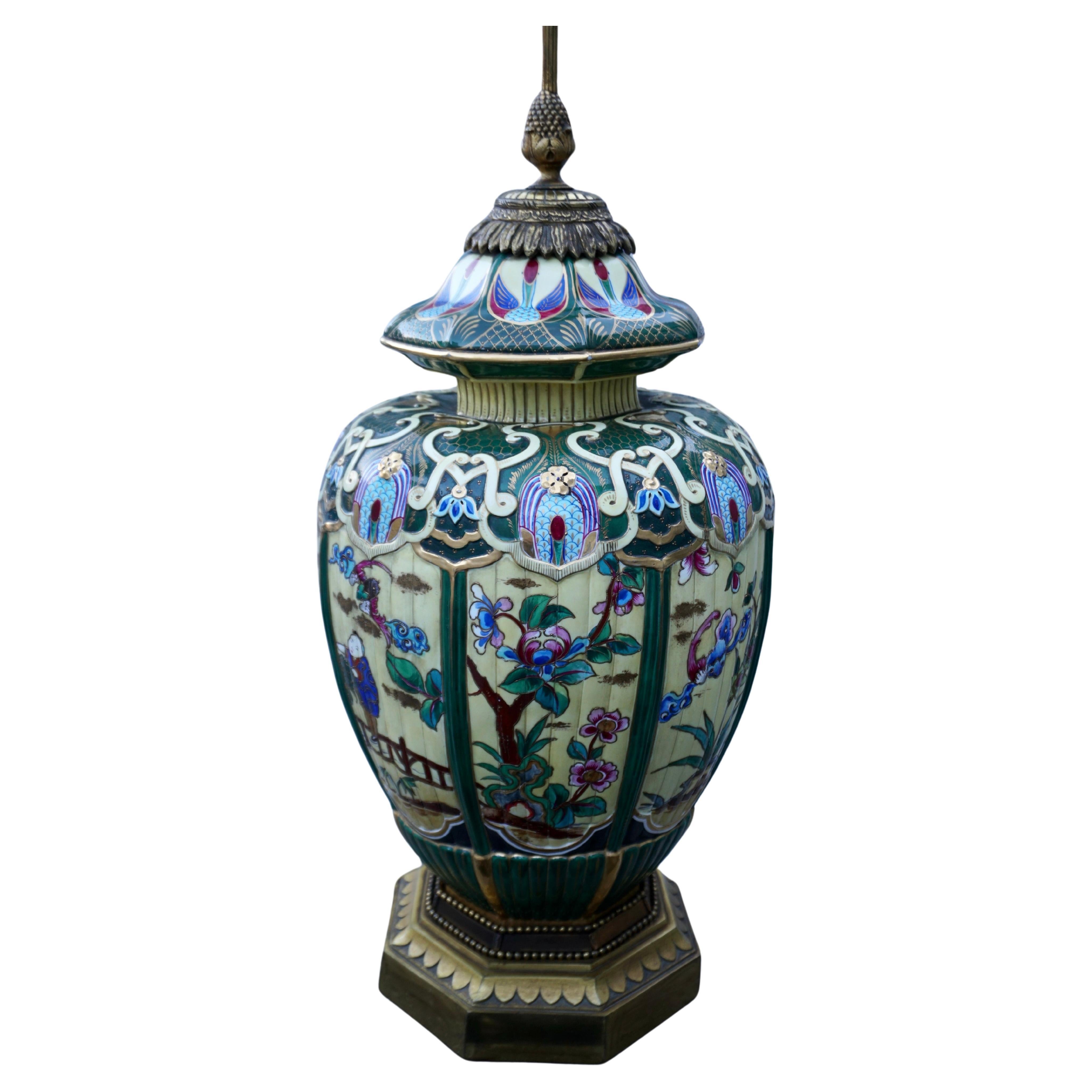 Vase japonais en faïence peint à la main, monté en lampe.

De forme ovoïde cannelée, peinte à l'imitation de l'émail cloisonné, avec des panneaux de personnages et d'animaux dans un jardin à l'intérieur de bordures cannelées, montée comme base de