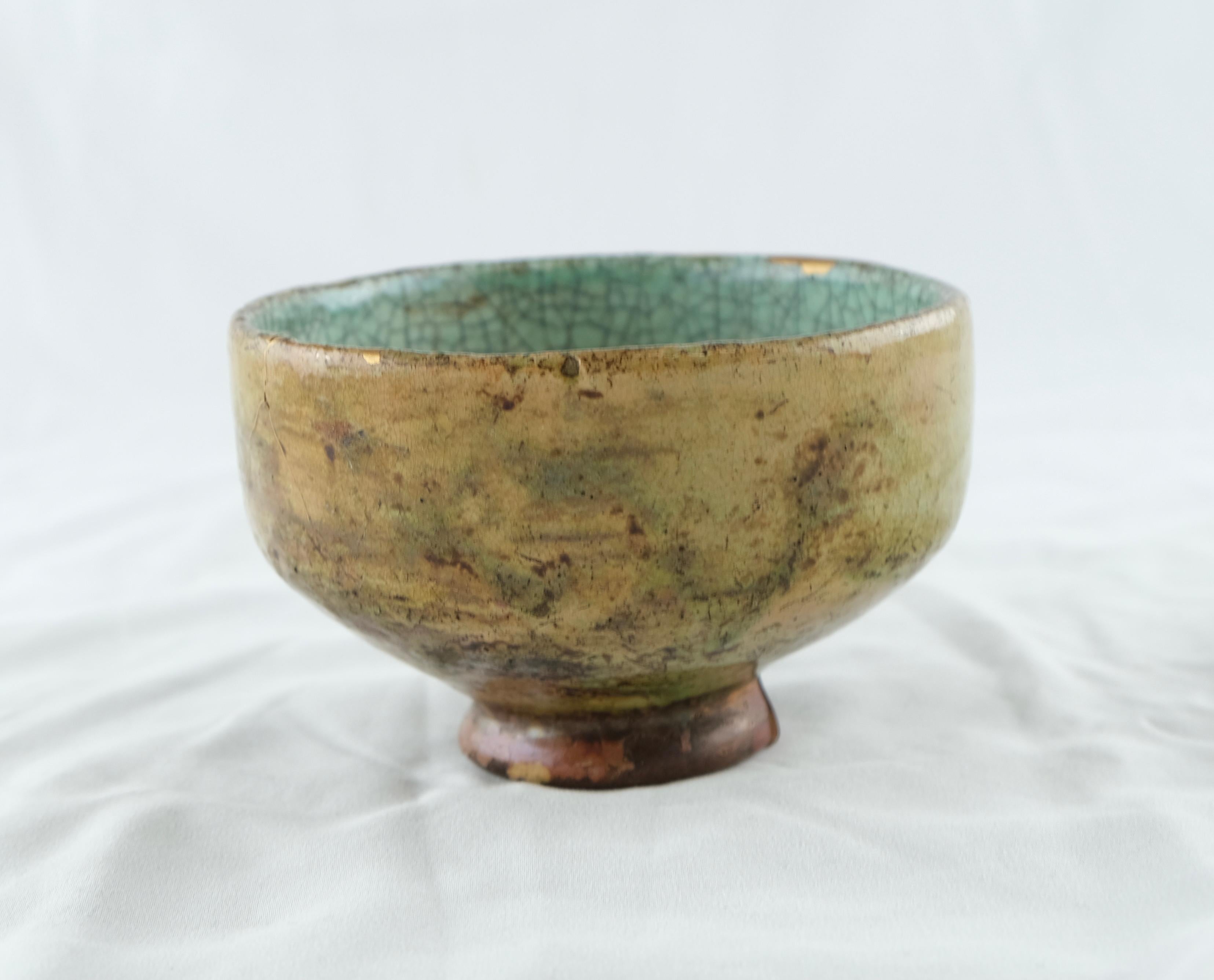 A well made Japanese Chawan. Earthenware glazed in yellow and turquoise colours. Some chips on the upper edge.
On the bottom there is an old marking, probably from a collection.