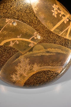 A Japanese Circular Maki-e Lacquer Box with Fan-Shaped Reserves
