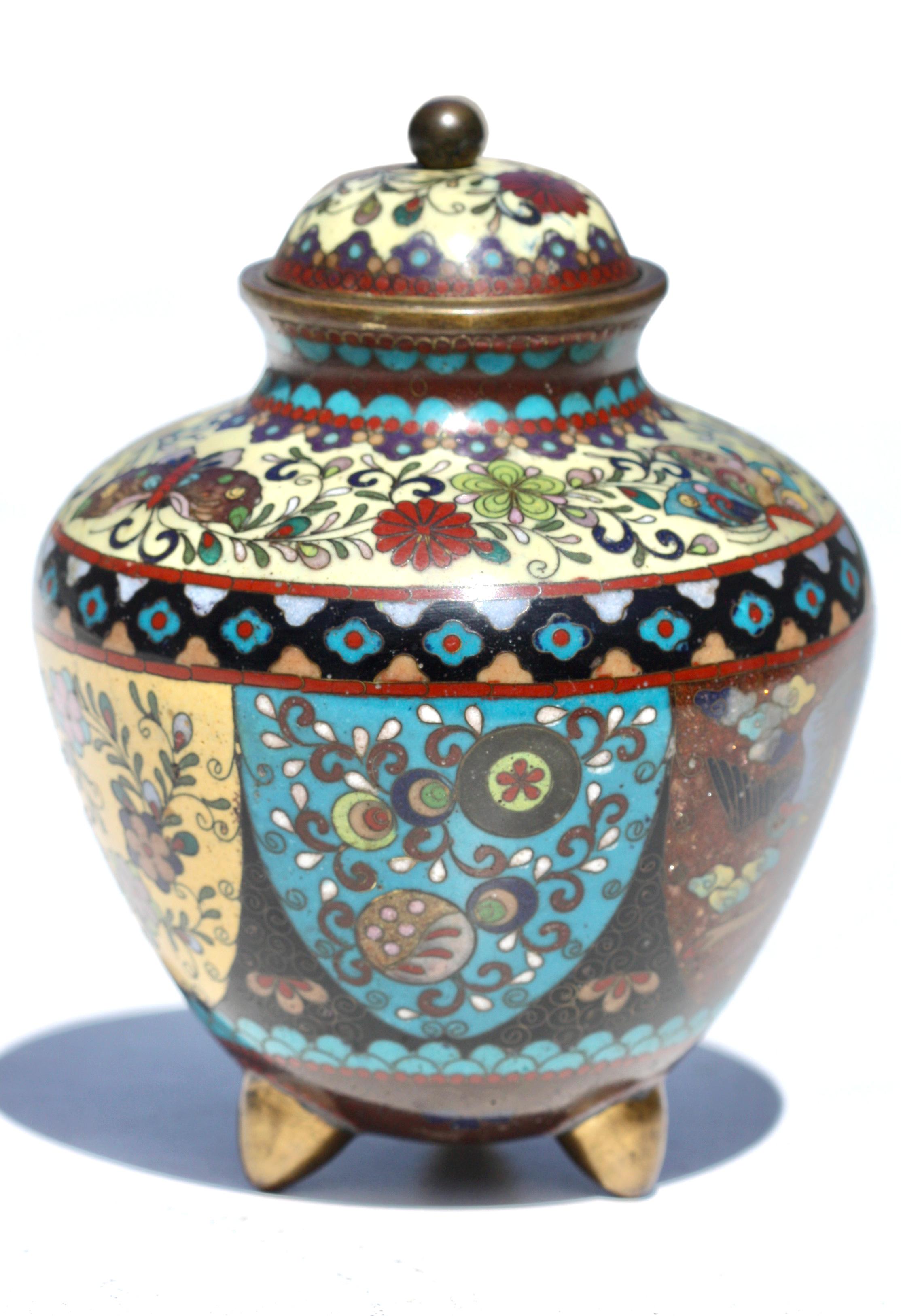 A Japanese Cloisonne vase and cover, Meiji period
finely decorated in silver and copper wire and a variety of coloured enamels with six panels, the body and cover with bands of lappets and geometric patterns supported by tripod feet,
Measures: