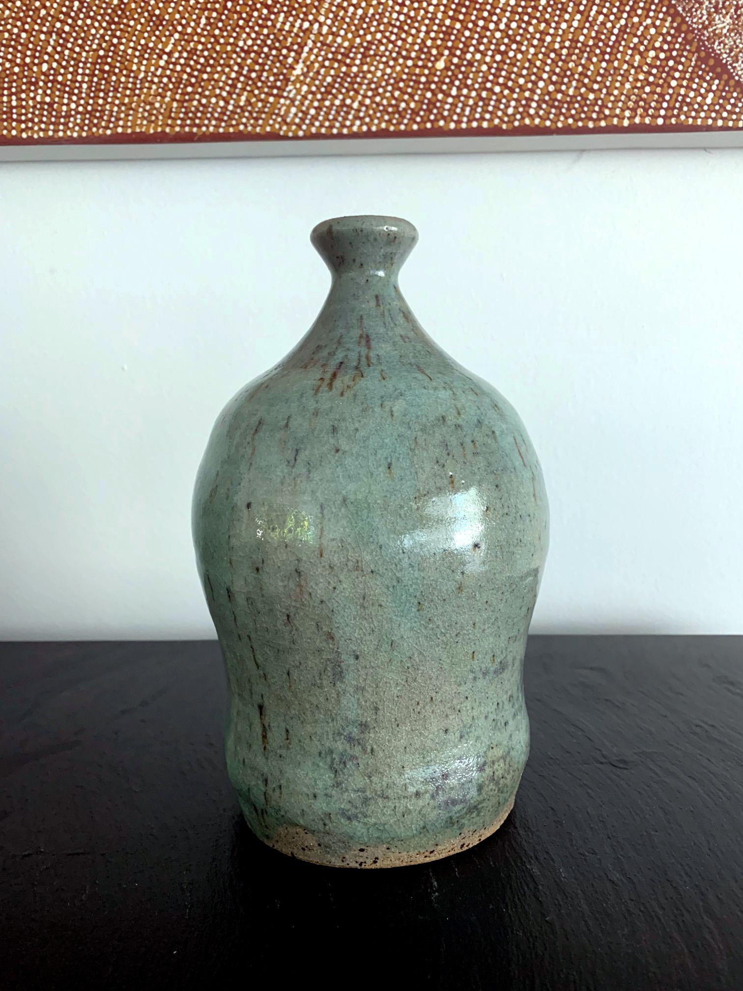 A ceramic bottle in the shape reminiscent of traditional saki bottle by Japanese potter Teruo Hara (1929-1985). The bottle was decorated with a dipping caledon glaze splashed with iron flecks for a random surface texture. The very lower part of