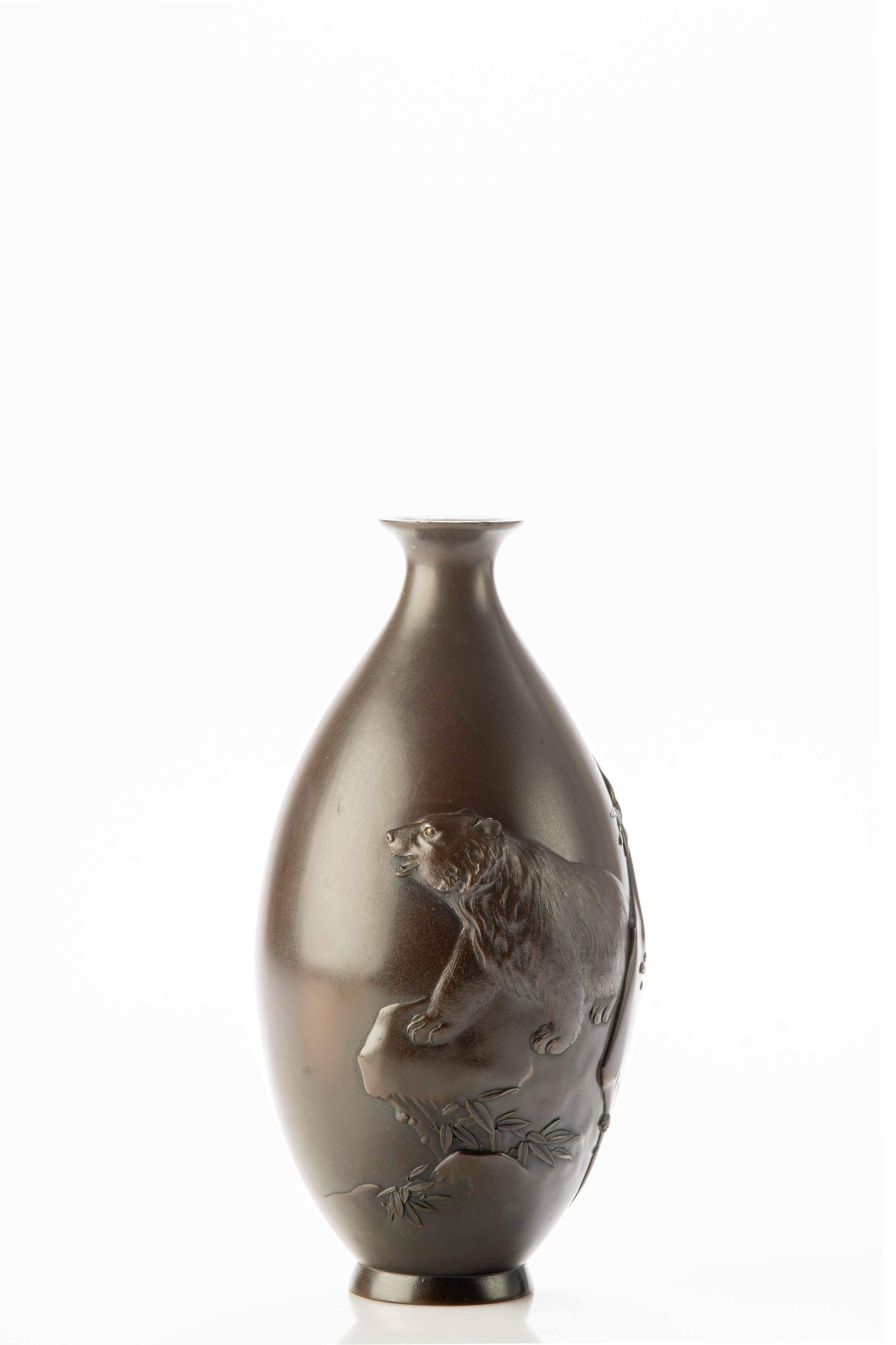 Vase japonais en bronze en forme de goutte travaillé avec une profondeur remarquable qui transforme l'œuvre en une scène tridimensionnelle époustouflante avec un ours majestueux en relief au centre qui se dresse puissamment sur un rocher.

L'ours