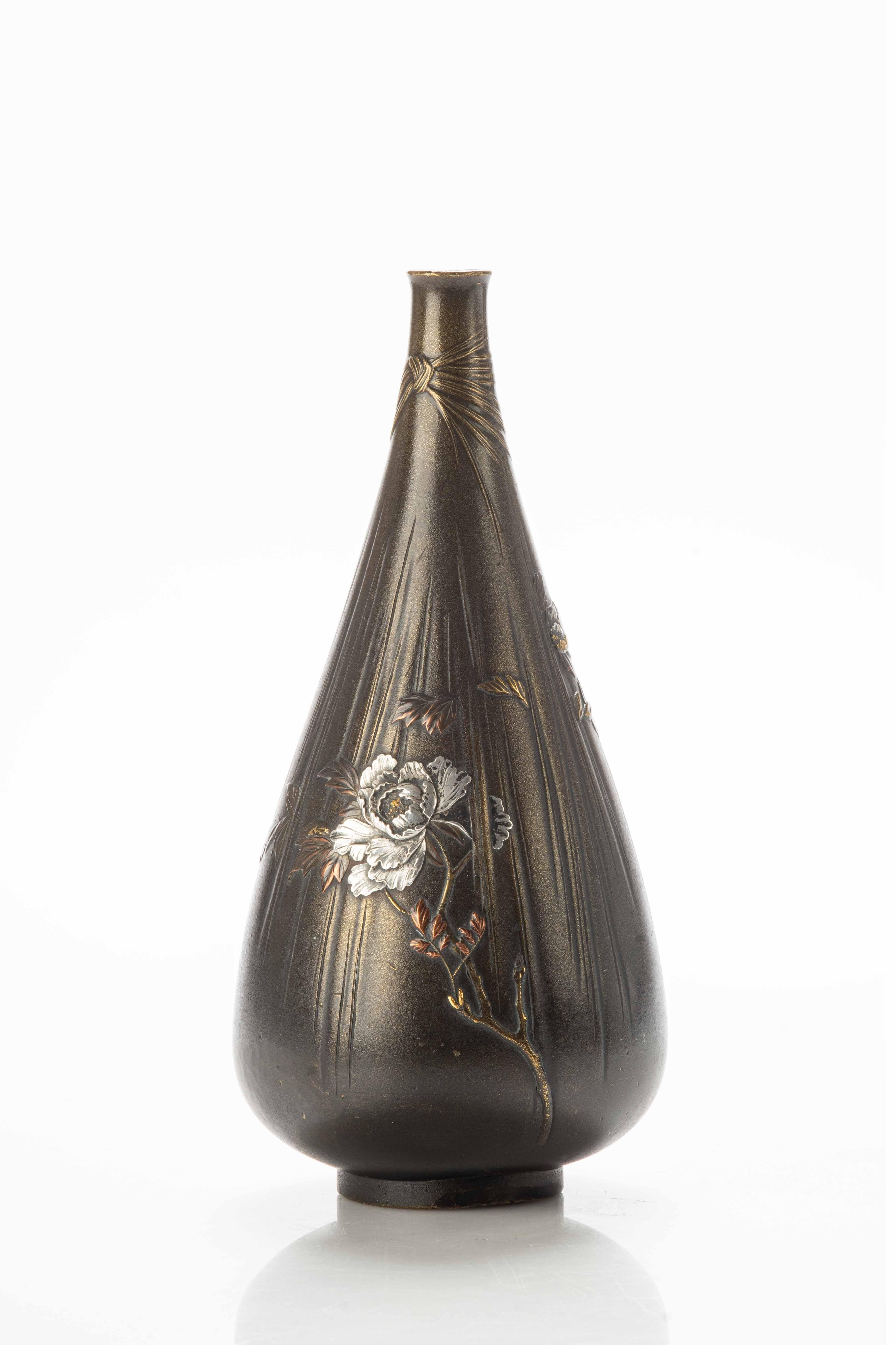 Drop-shaped bronze vase, with peonies in relief, decorated to simulate a delicate and light fabric that ends with a bow near the top of the neck.

Using mixed metals to create visual contrasts adds depth and beauty.

Signed Gyokkō 玉光 on the side of