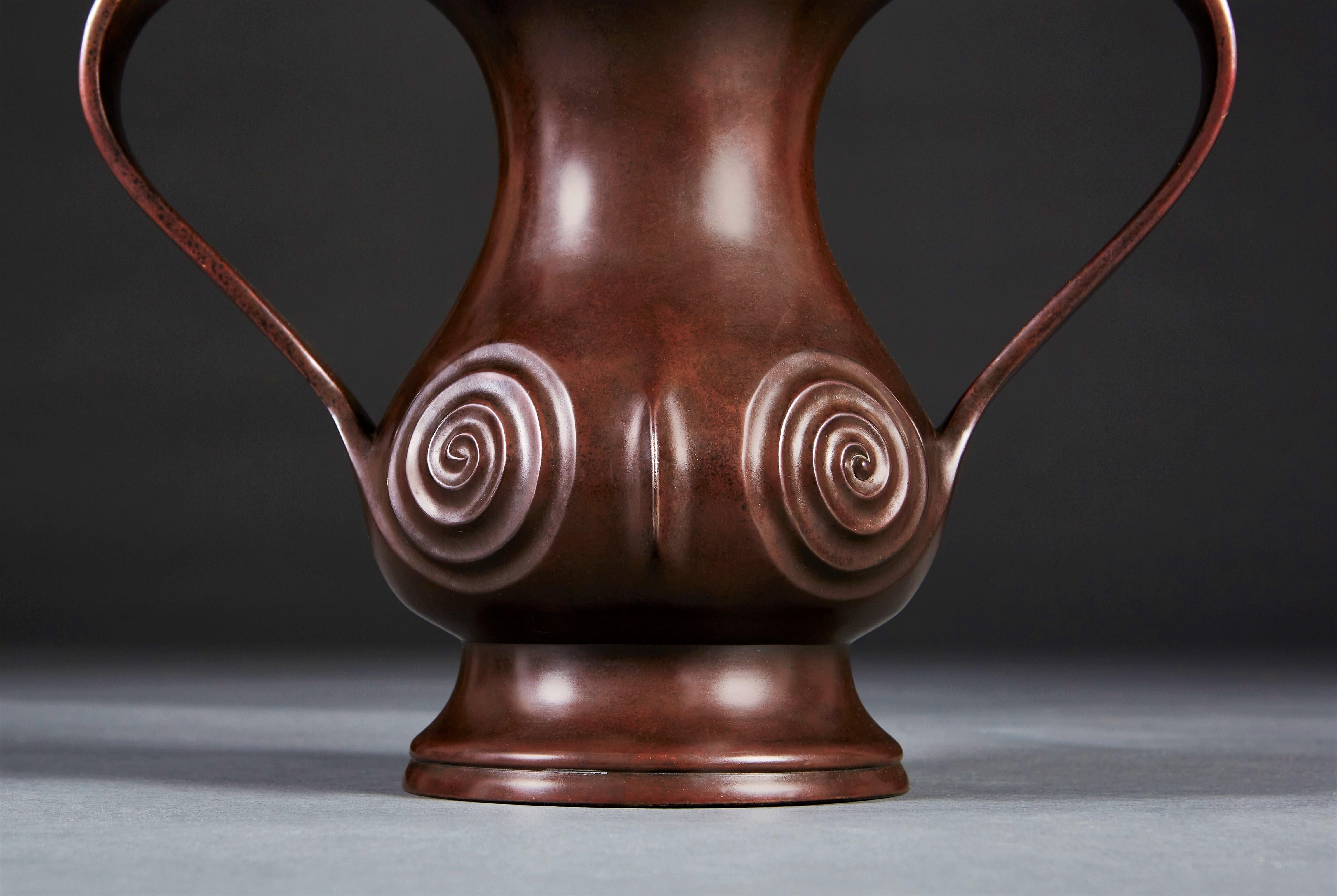 A rare Edo period bronze vase with Mimikuchi flying handles, with quartered pear shaped body with spiral to the front and back, supported on a flared base.
