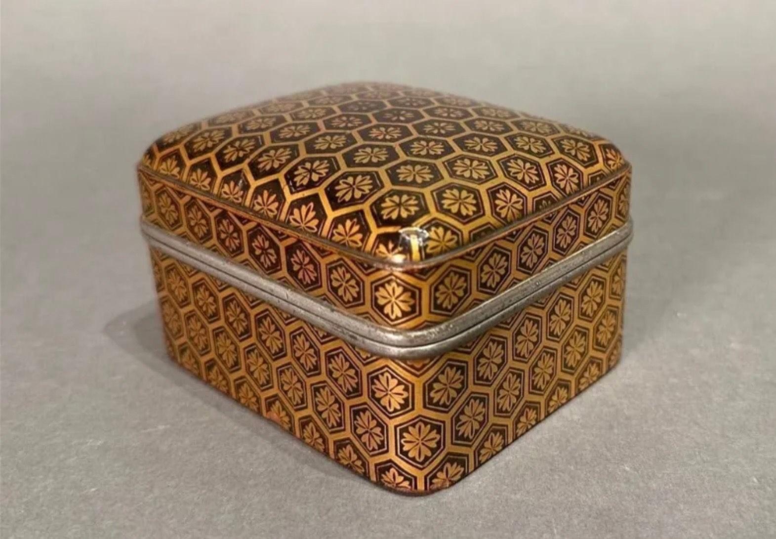 Early Japanese Lacquer Incense Box (Kogo) Late 17thc. Of rectangular form with soft corners, decorated with a diaper pattern in gold lacquer on a brownish black ground, with pewter rims.
Dimensions: 2.25 × 4 × 2.5 in.
Condition: Some age appropriate