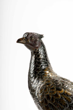 A Japanese gilt and patinated bronze okimono of a pheasant