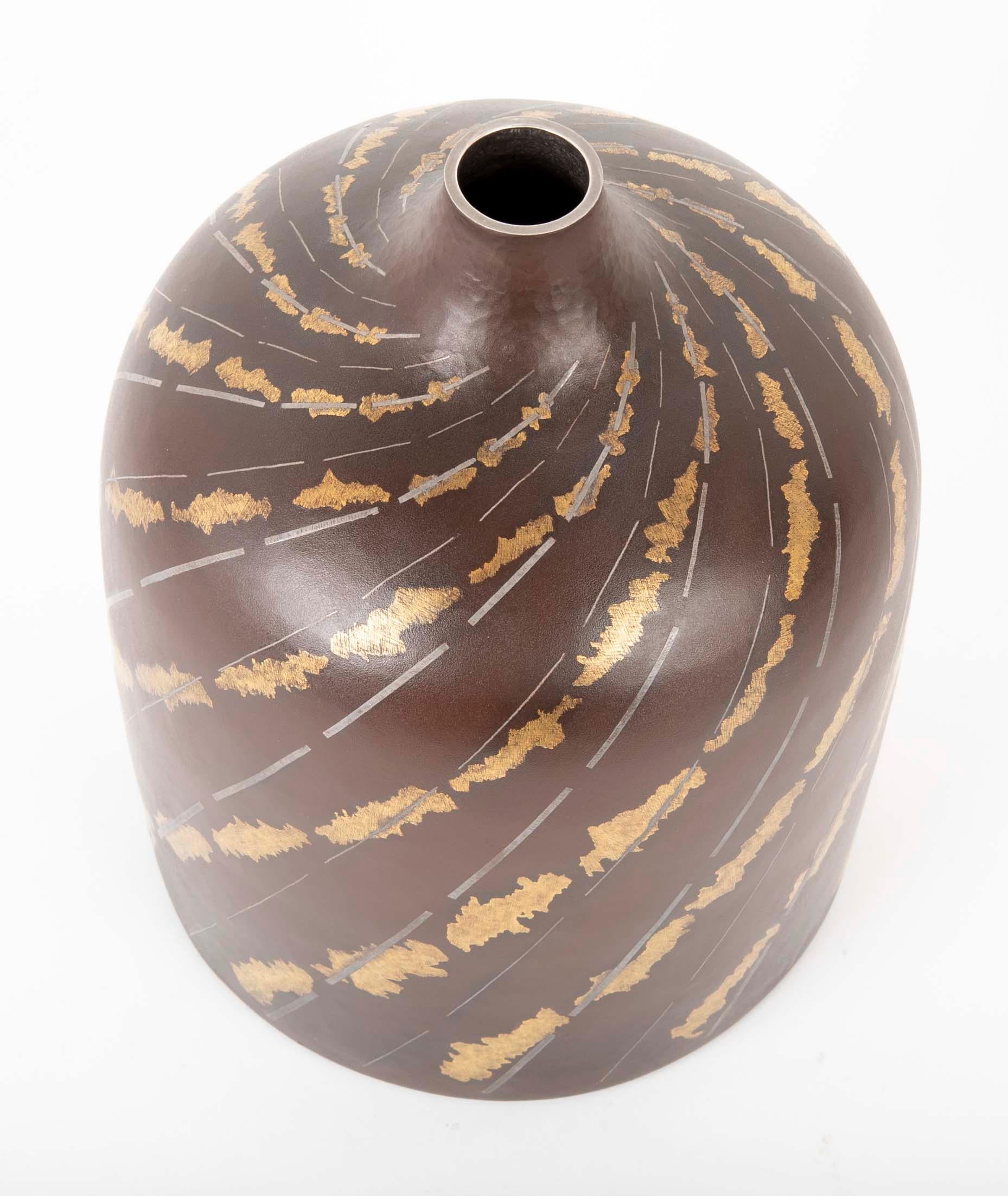 Vase Ikebana cylindrique en fer avec un motif en spirale argenté et doré représentant un ruisseau. Le vase a été réalisé par Ueda Hiroshi et est signé Hiroshi. La boîte est accompagnée de son Tomobako (boîte de rangement) d'origine et porte