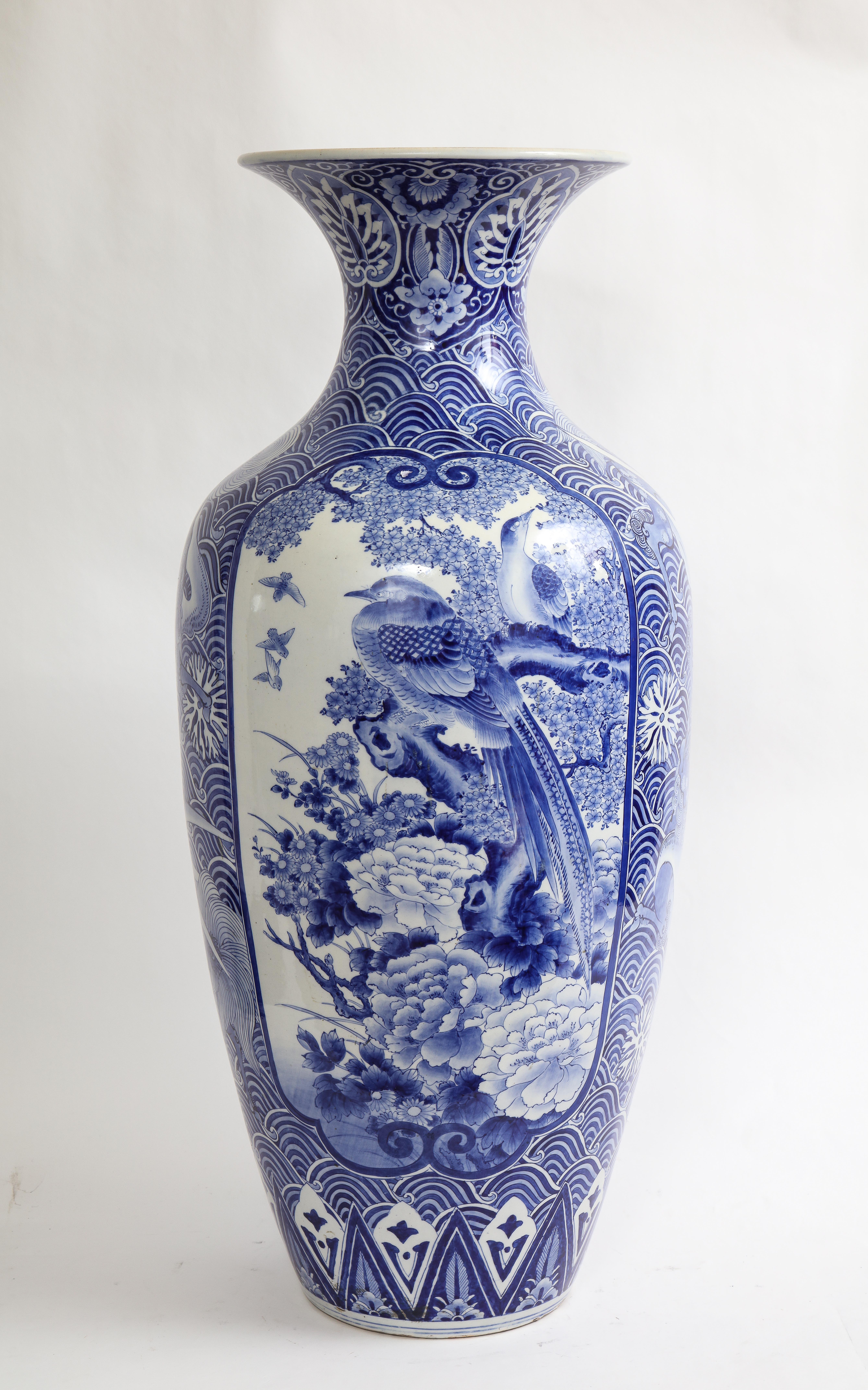 Vase bleu et blanc de taille Palace de la période Meiji (1868-1912) à décor de phénix. Ce vase est absolument magnifique avec un incroyable éventail de décorations bleues peintes à la main. De chaque côté du vase se trouvent de grands cartouches