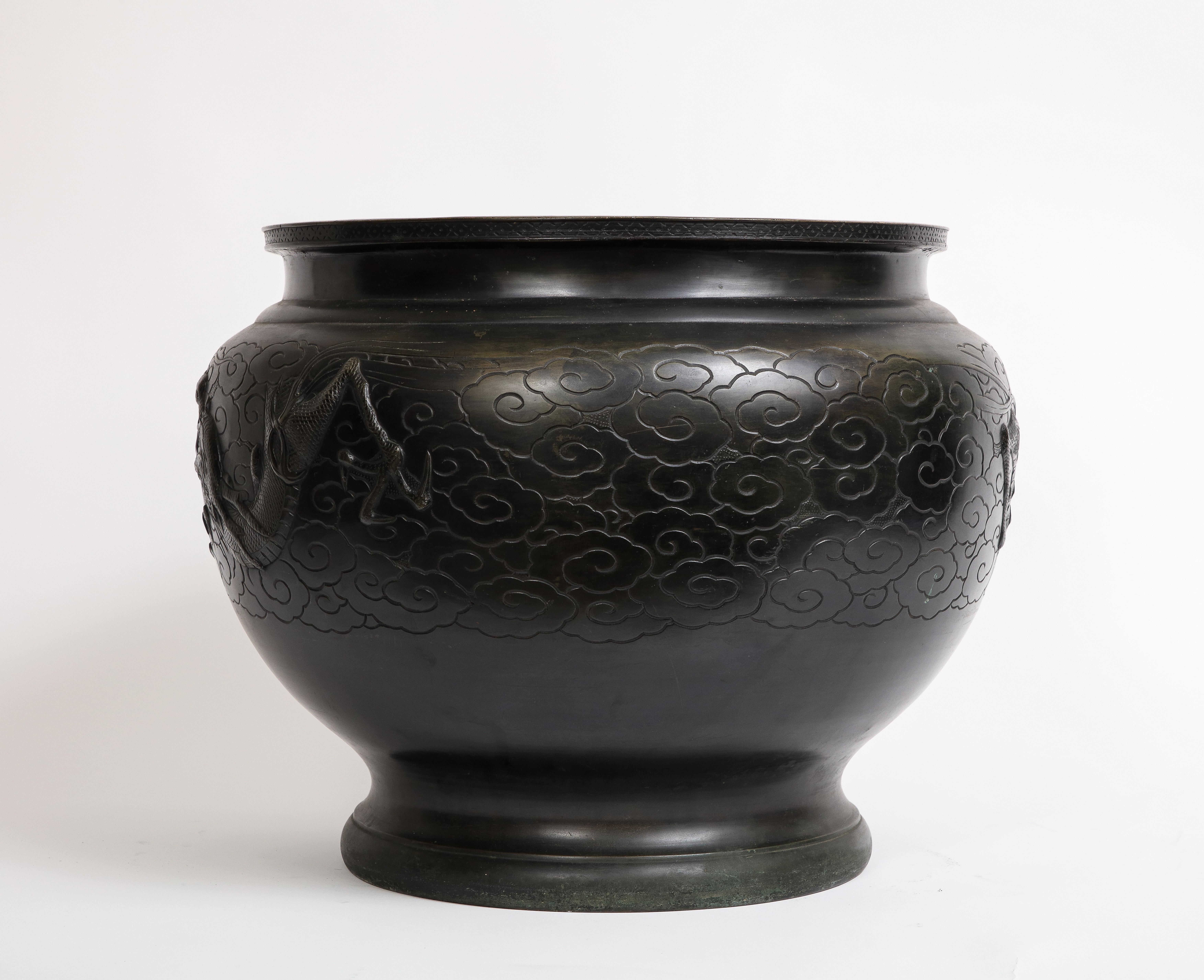 A Fantastic and large Japanese Meiji Period Patinated Bronze Centerpiece/Bowl/jar denier with Dragon in Relief.  This captivating and exquisite, hand-crafted, patinated bronze centerpiece serves as a remarkable focal point, adorned with marvelously