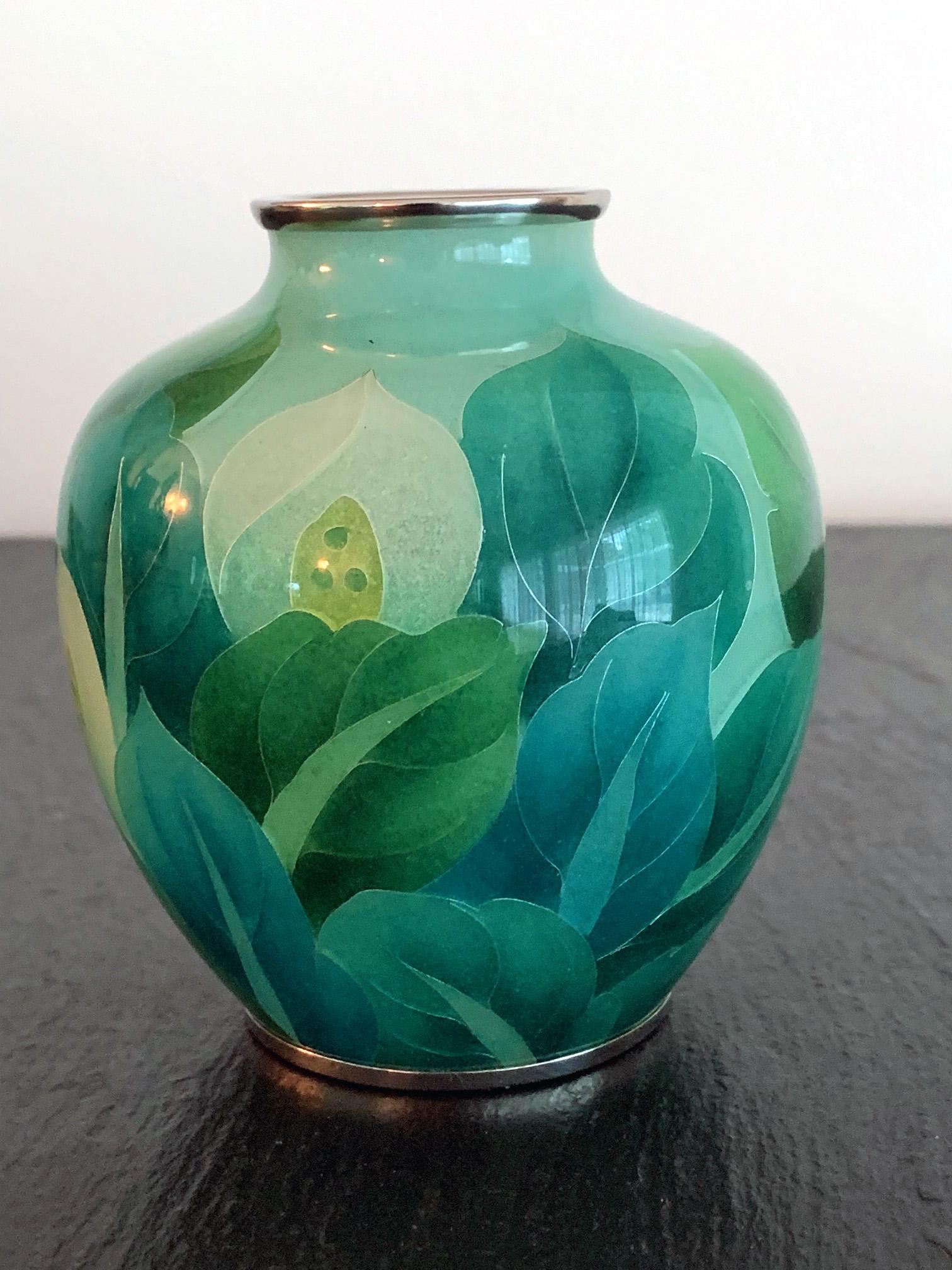 An exquisite plique-à-jour cloisonne vase by Ando Company, likely mid-late 20th century. A work of art, this baluster shaped vase is crafted with the most refined designs and technique. The pattern features large bundles of white calla lilies and