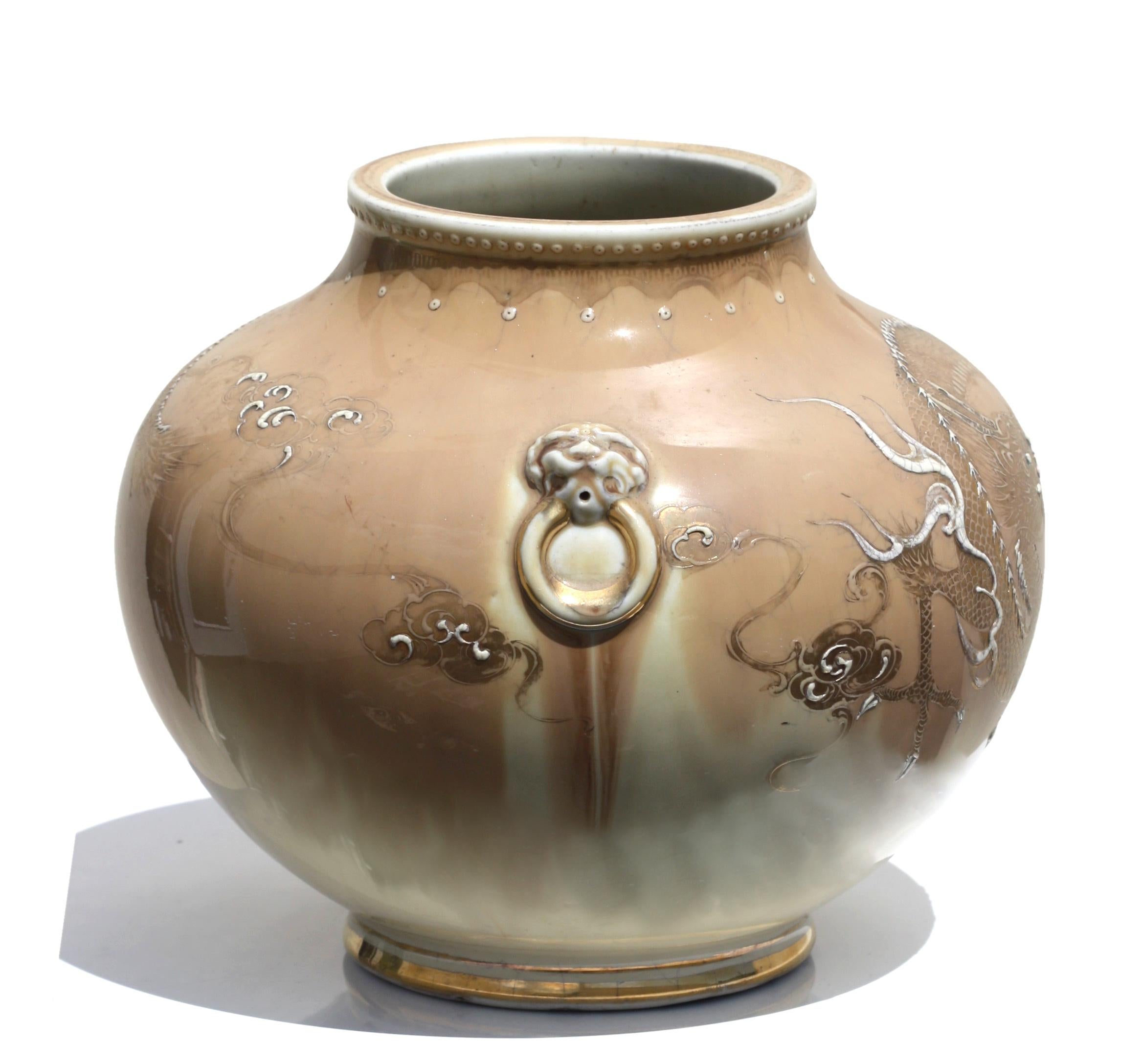 A Japanese Porcelain globular jar with dragon design on a light brown ground, early 20th century, 10 by 8 in. (25.4 x 20.32 cm.).