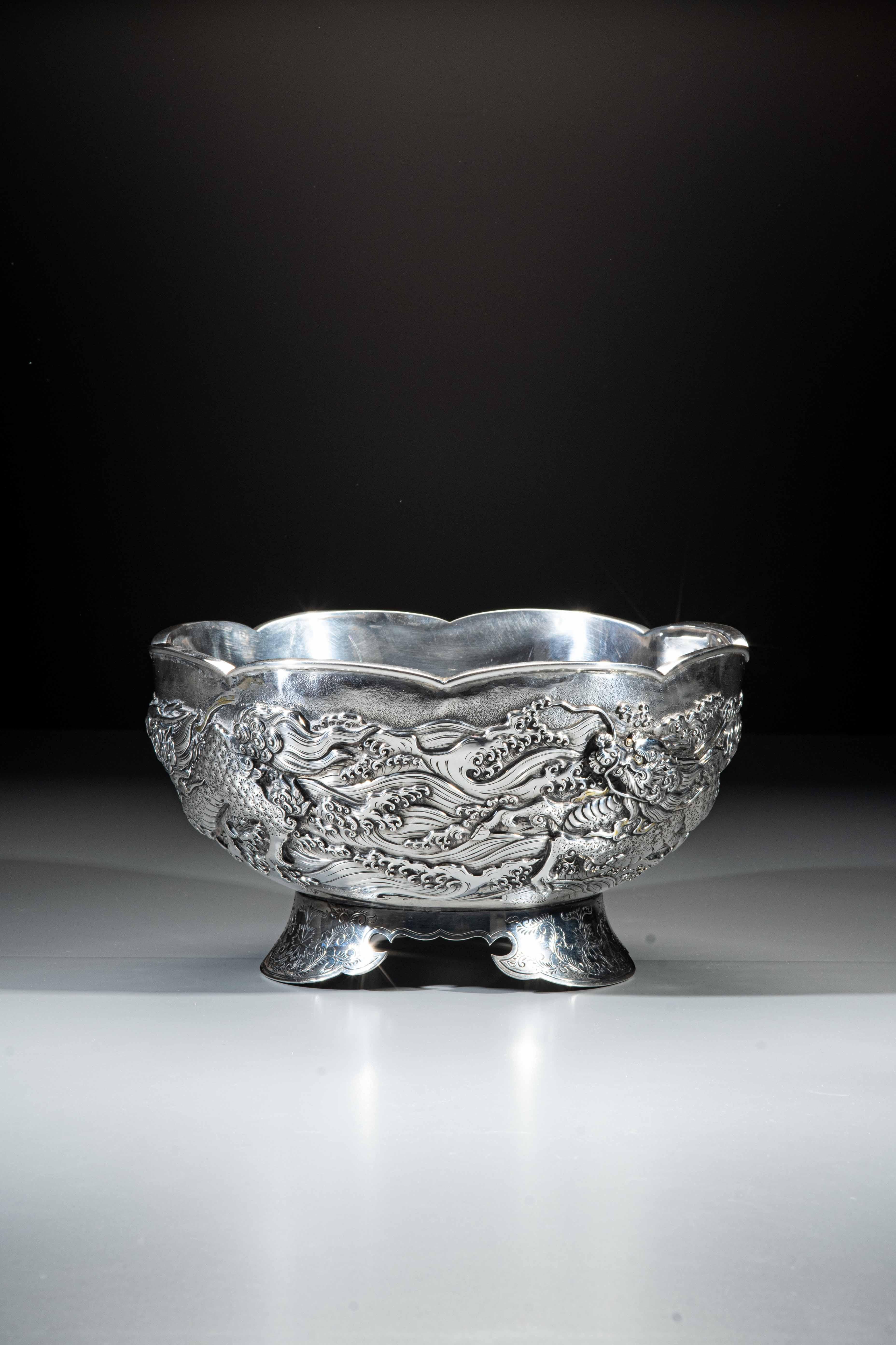 A Japanese silver bowl with lobed edge, worked in kebori and repoussé with three kirin in relief, finely chiseled and adorned with gilding that emerges from the waves and embraces the entire surface of the bowl, signed Murasaki No Miyako Nemoto Zo