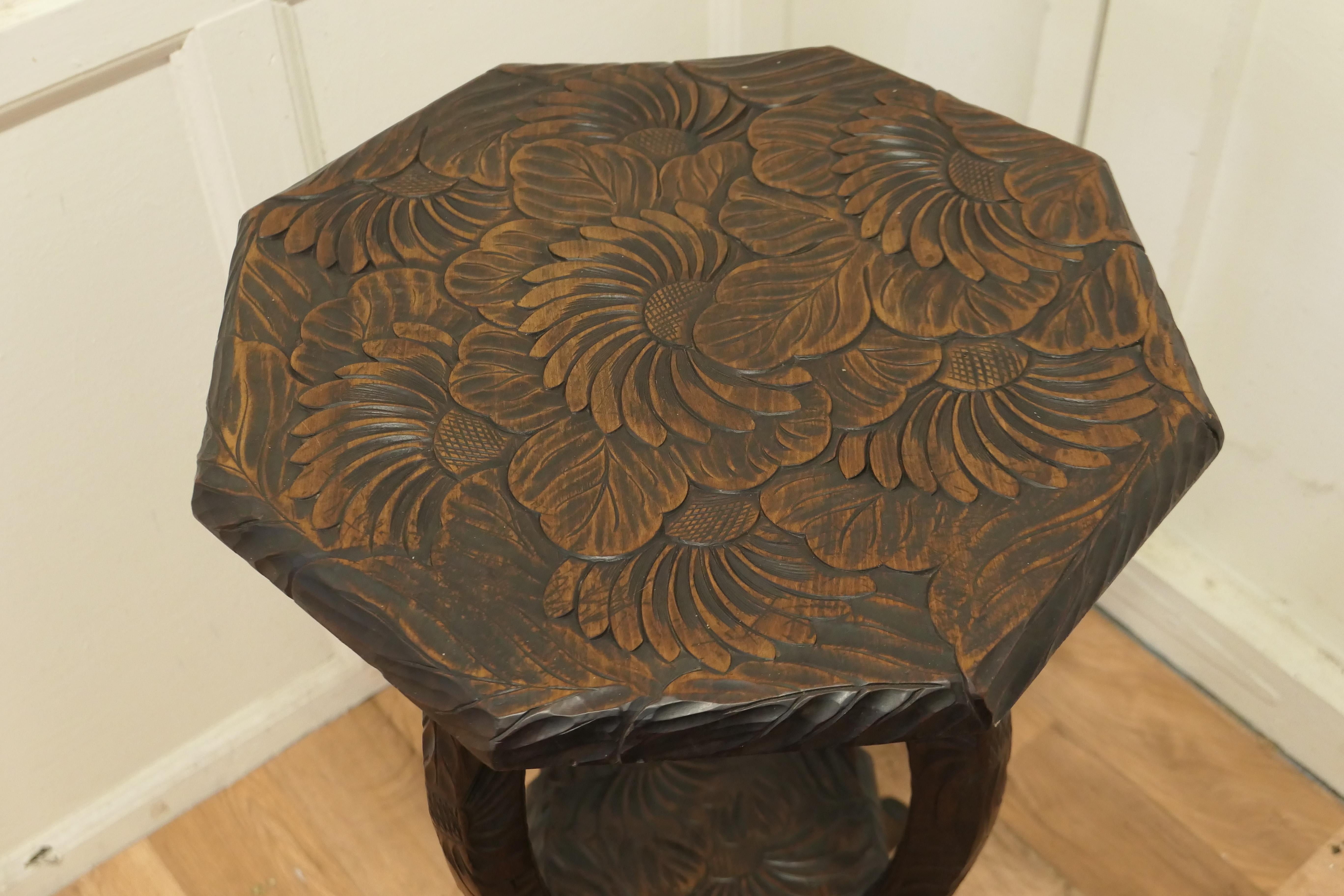 A Japanese table Carved for Liberty of London 
The octagonal top is beautifully carved with flowers it is set on swept out cabriole style legs which are also carved on all sides.The table has an under tier shelf which is also carved
Superb