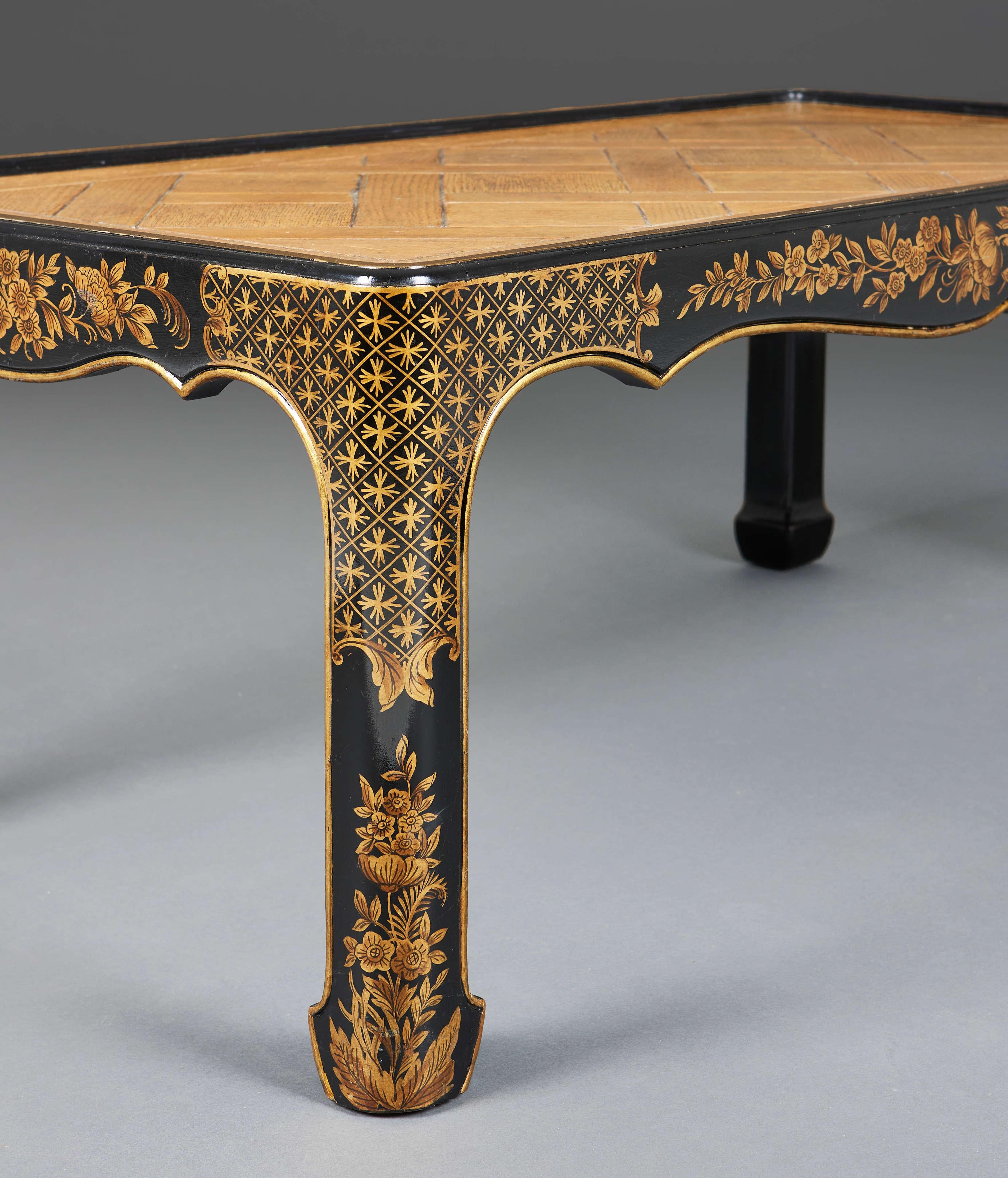 An unusual early twentieth century Japanned black and gold lacquer low table base, with floral decoration throughout, with inset parquetry oak panels to the top.