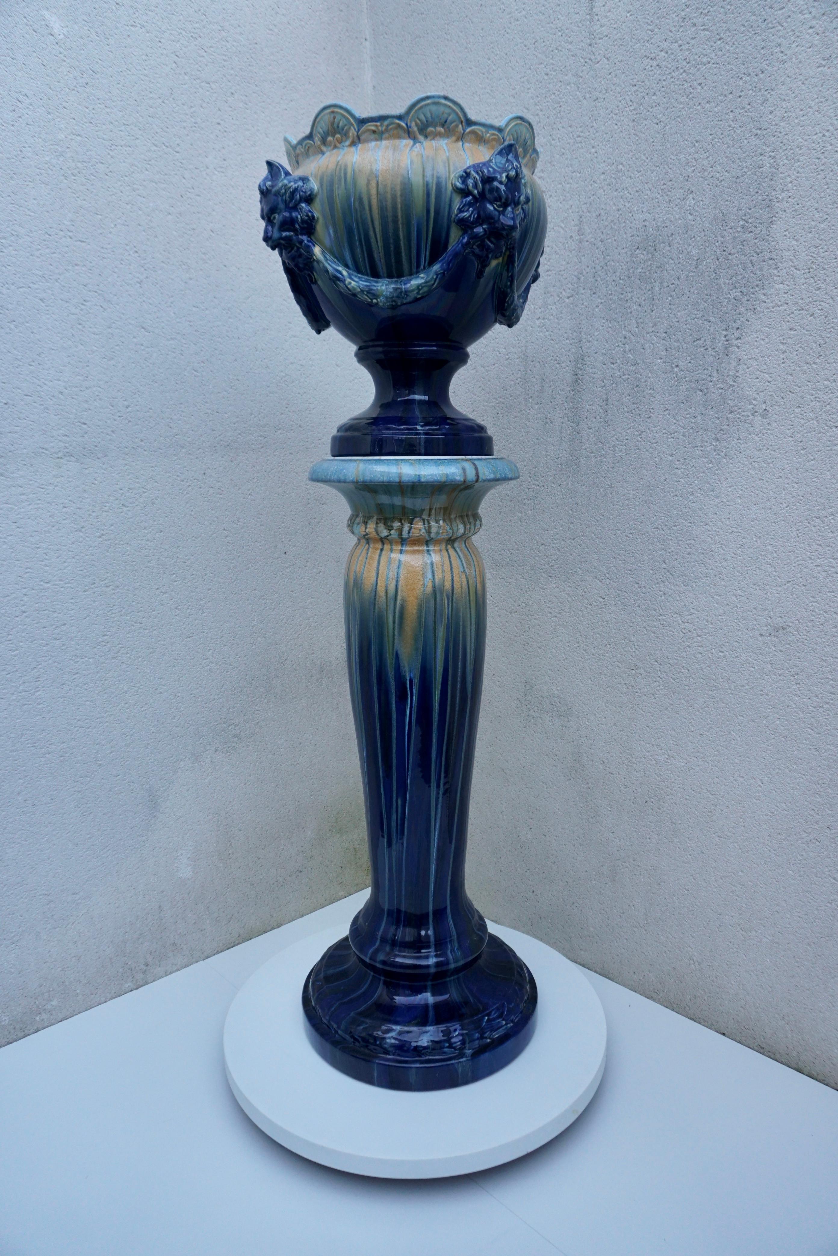 A jardiniere or planter on a stand with lion head decor in Flemish earthenware style. Art Nouveau Majolica jardinière, planter with stand in the style of Delphin Massier & Fils at Vallauris. The jardinière is exactly matched to the stand on which it
