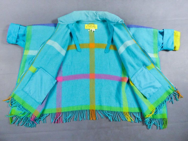 Circa 1990
France

Ko And Co wool poncho coat by Jean-Charles de Castelbajac from the 1990s. Light blue brushed wool poncho effect with fringes and yellow, white and pink stripes forming large checks. Internal pockets, double raised collar and