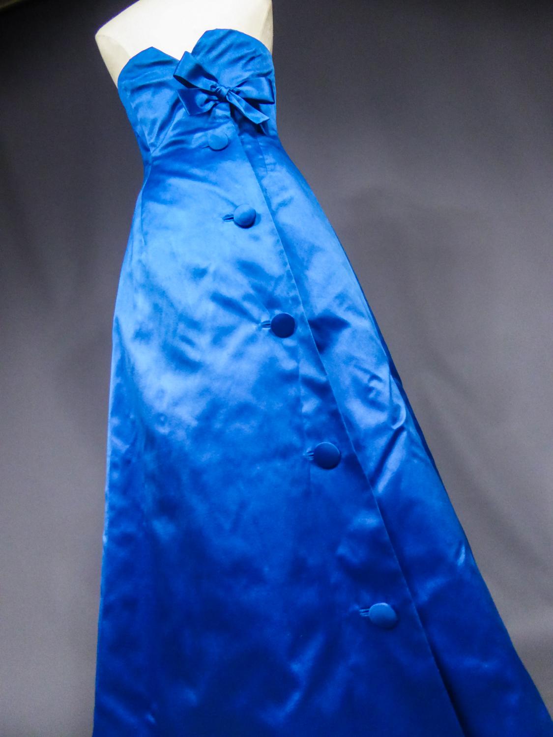 Circa 1959/1962

France

Beautiful evening dress in electric blue satin from the Jean Patou House directed by Karl Lagerfeld between 1959 and 1962. Long dress in sheath hugging the hips, treated assymetrically in the back with matching buttoning,