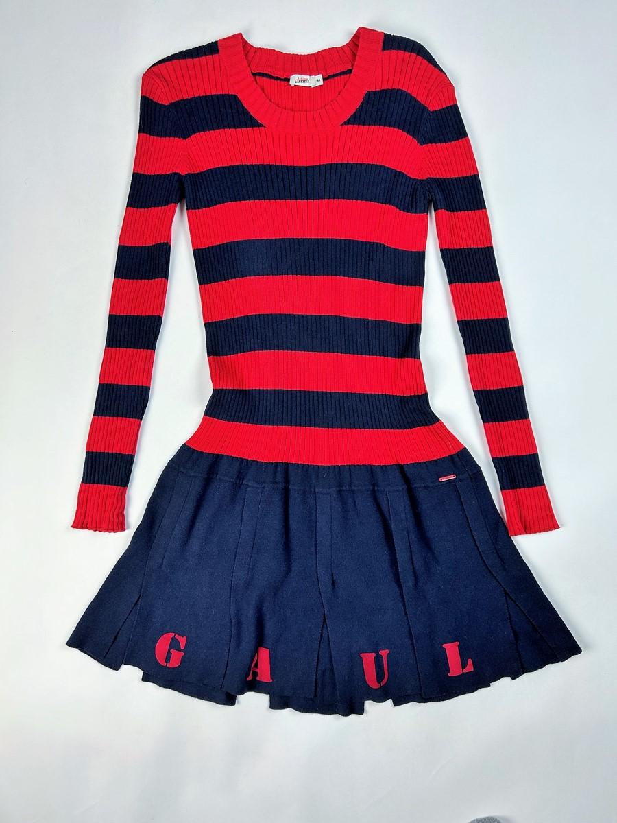 Circa 2000

France

Navy mini-dress in ribbed cotton knit from Jean-Paul Gaultier's Junior collection dating from 2000. Stretch dress with a form-fitting silhouette, oval collar and long sleeves. Treated with wide navy and red horizontal stripes