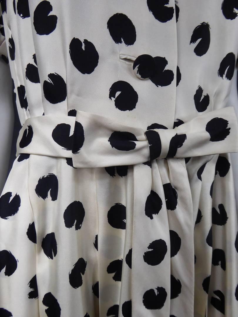 Circa 1960 France
Silk dress with black polka dots on a white background accompanied by a similar bow belt and fringed pans, by the Jeanne Lanvin House directed by Antonio Castillo and dating from the 1960s. Front closure by three buttons in the