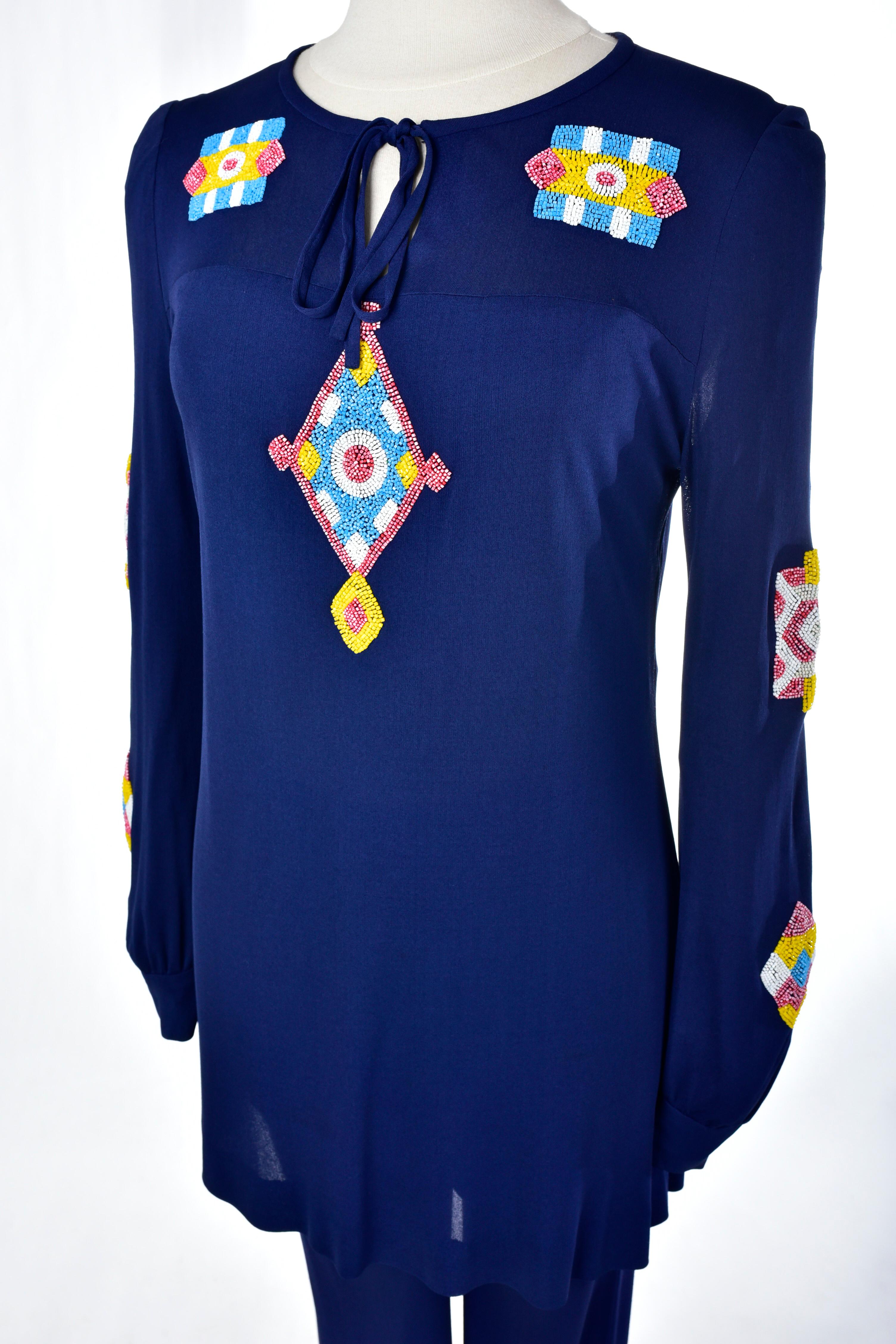 Circa 1975

France Haute Couture

Beautiful evening pajama set in stretch navy silk jersey with ethnic embroidery by the famous designer Louis Féraud and dating from the 1970s. Loose tunic tied in front, long sleeves closed at the wrists by two