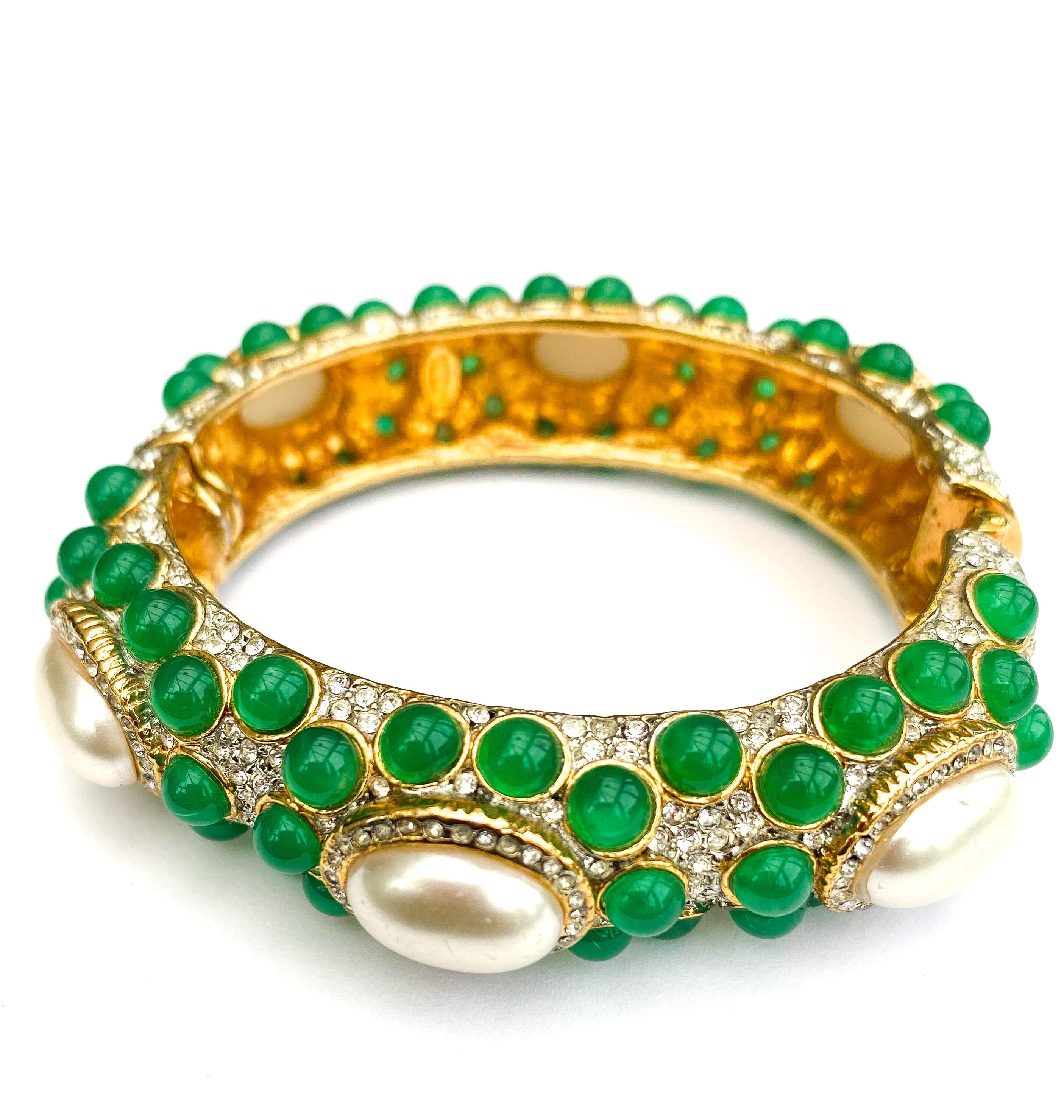 A beautiful jewelled bangle, in emerald glass cabuchons, clear paste and paste pearl cabuchons, 
in the style of Moghul jewellery, sparkling and eye catching. With a firm 'snap clasp' an easy to wear jewel, reminiscent of the 'Swans' and New York