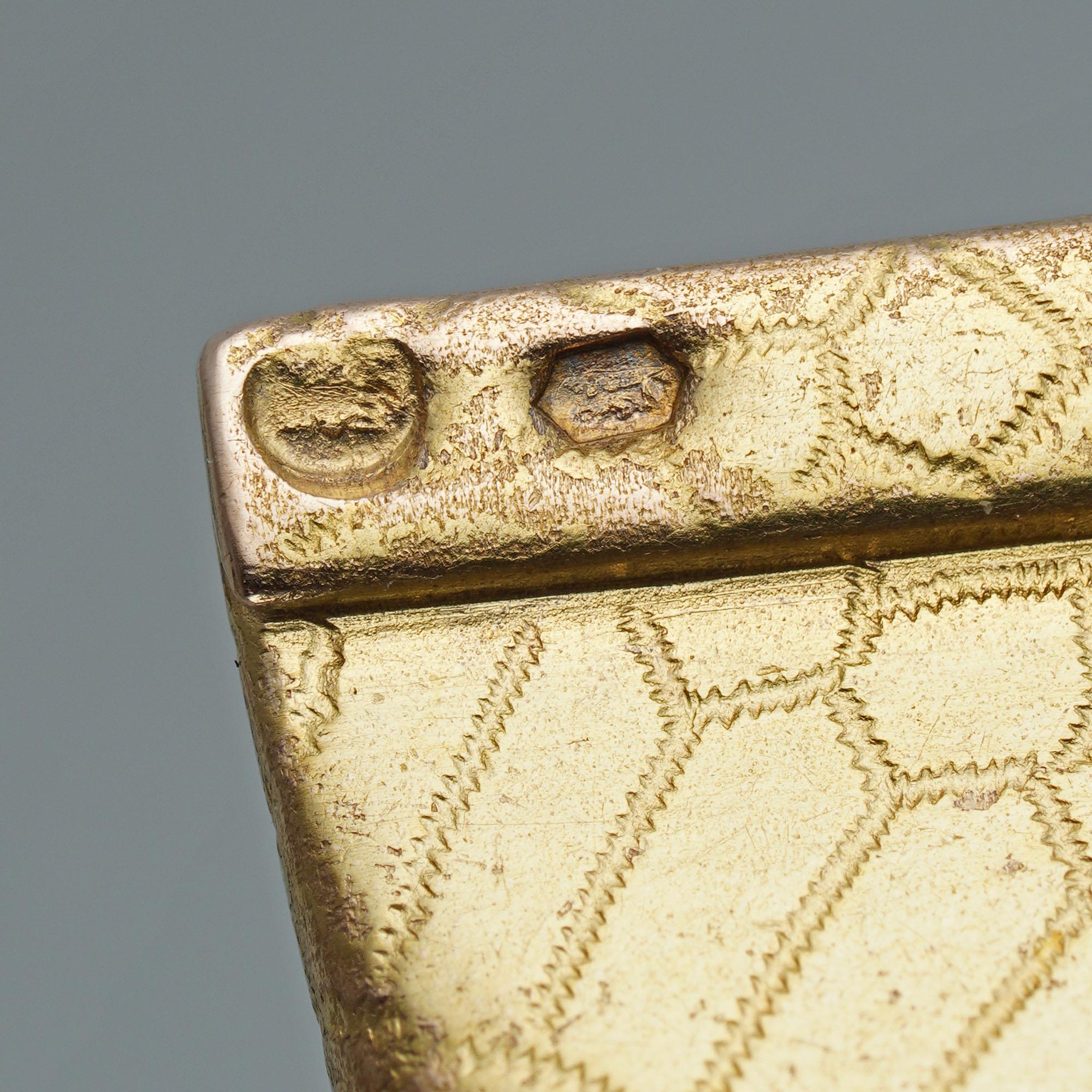 Un flacon de parfum en or orné de bijoux, attribué à Fabergé, en forme de tube de peinture avec couvercle amovible, le tout finement gravé pour imiter la texture du cuir de serpent, l'avant portant une étiquette avec un fer à cheval porte-bonheur,