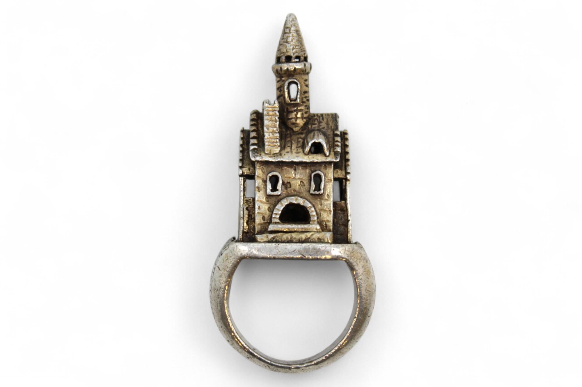 This exceptional Jewish wedding ring, likely crafted in Germany around 1800, is a striking and symbolic piece, richly imbued with tradition and meaning. Unlike conventional rings, this one is architecturally sculpted in the form of a large house, a