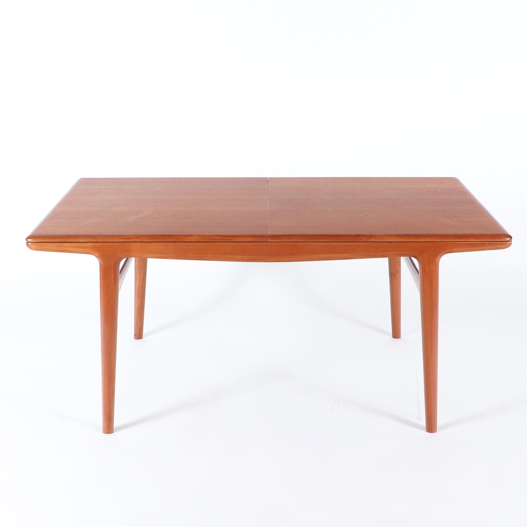 A Johannes Andersen mid century modern teak dining table with built in leaves circa 1960. Leaves measuring 17.75