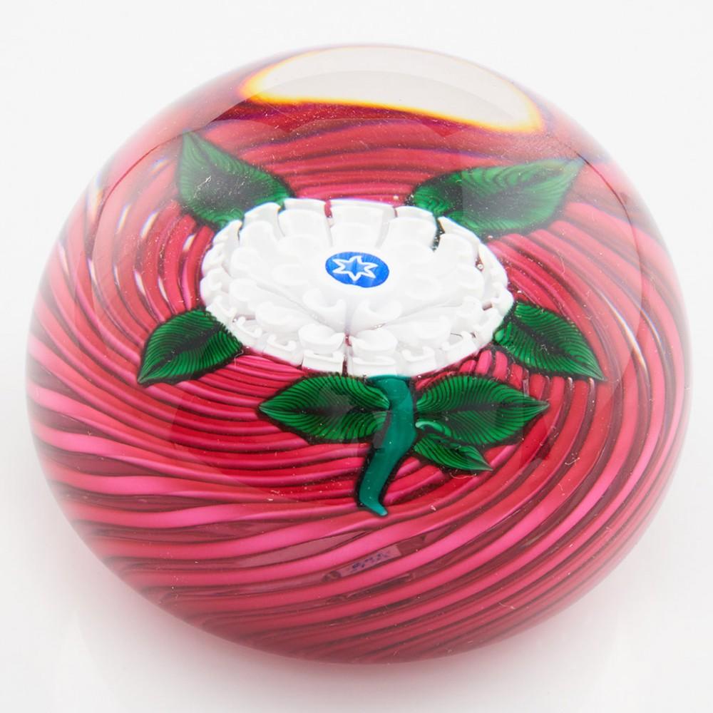 Heading : A John Deacons Pompom Lampwork Paperweight 2010
Date : 2010
Origin : Scotland
Features : White and green millefiori flower, stem and leaves on a crimson swirl gound
Marks : John Deacon Label and JD 2010 cane to the base
Type : Lead
Size :