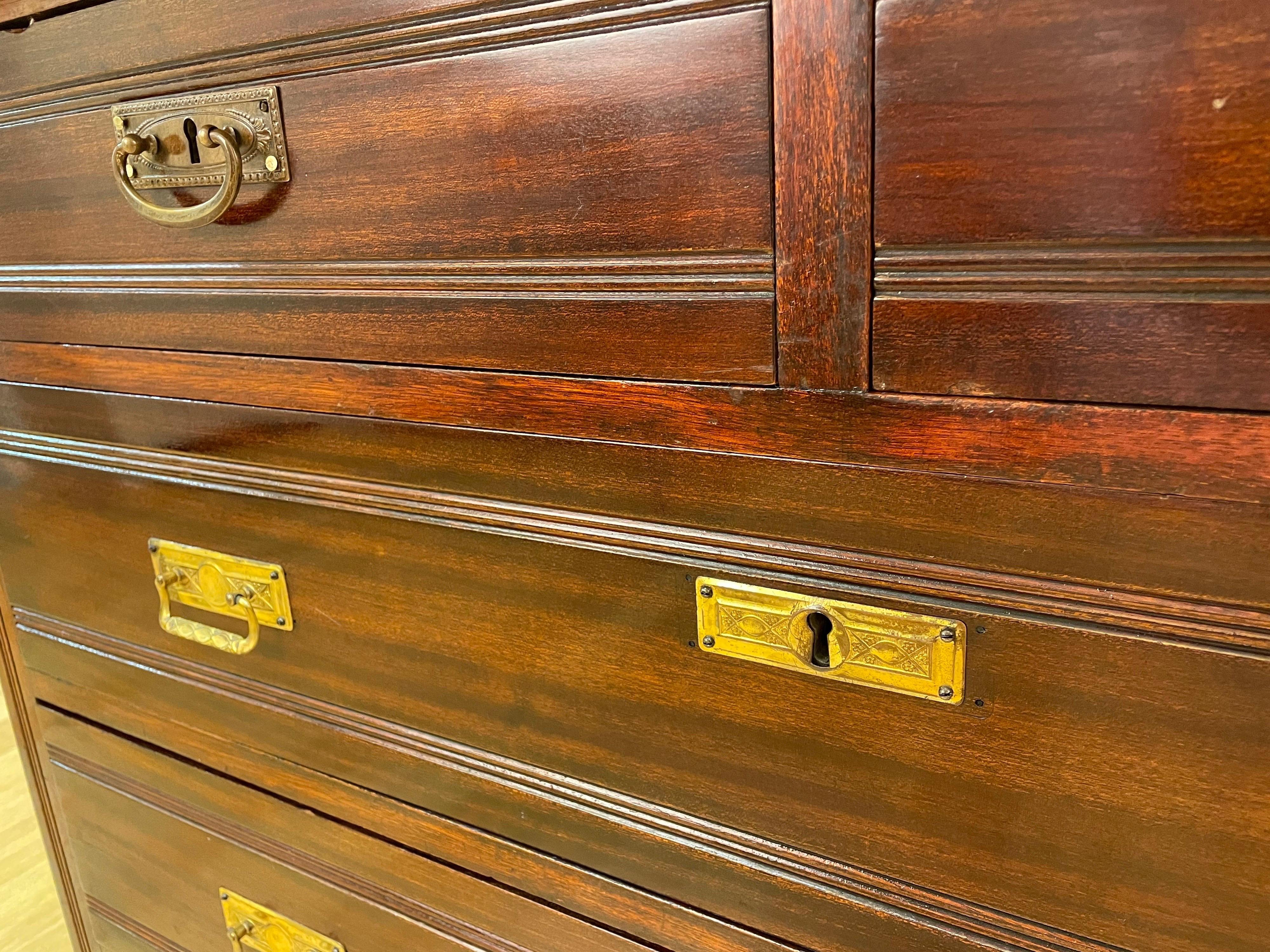 This deeply stained mahogany chest of drawers exhibits the style of the the turn of that century, with three lower drawers, a pair of upper drawers, all locking. The original hardware, pulls and key perfectly match the Jugend period's aesthetic.