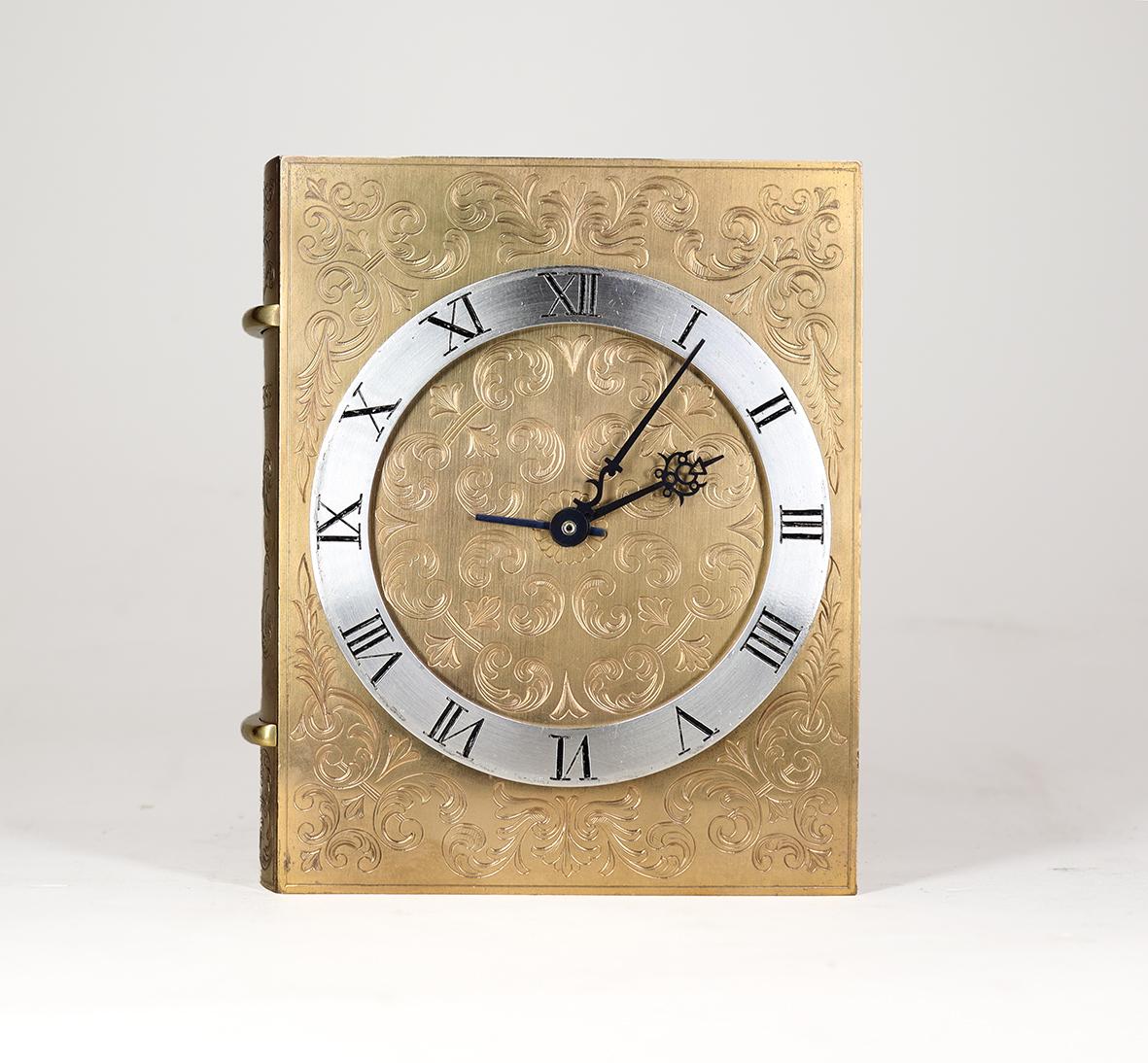 An extremely stylish and beautifully made Livre D'heures Alarm clock, in the shape of a small book, the case made of gilded brass is engraved on all sides and beautifully fitted together. The eight day movement made by Angelus is in remarkable