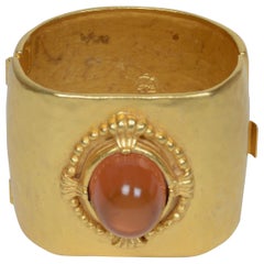 Un bracciale martellato e dorato di Karl Lagerfeld con un grande cabochon di ambra Gripoix