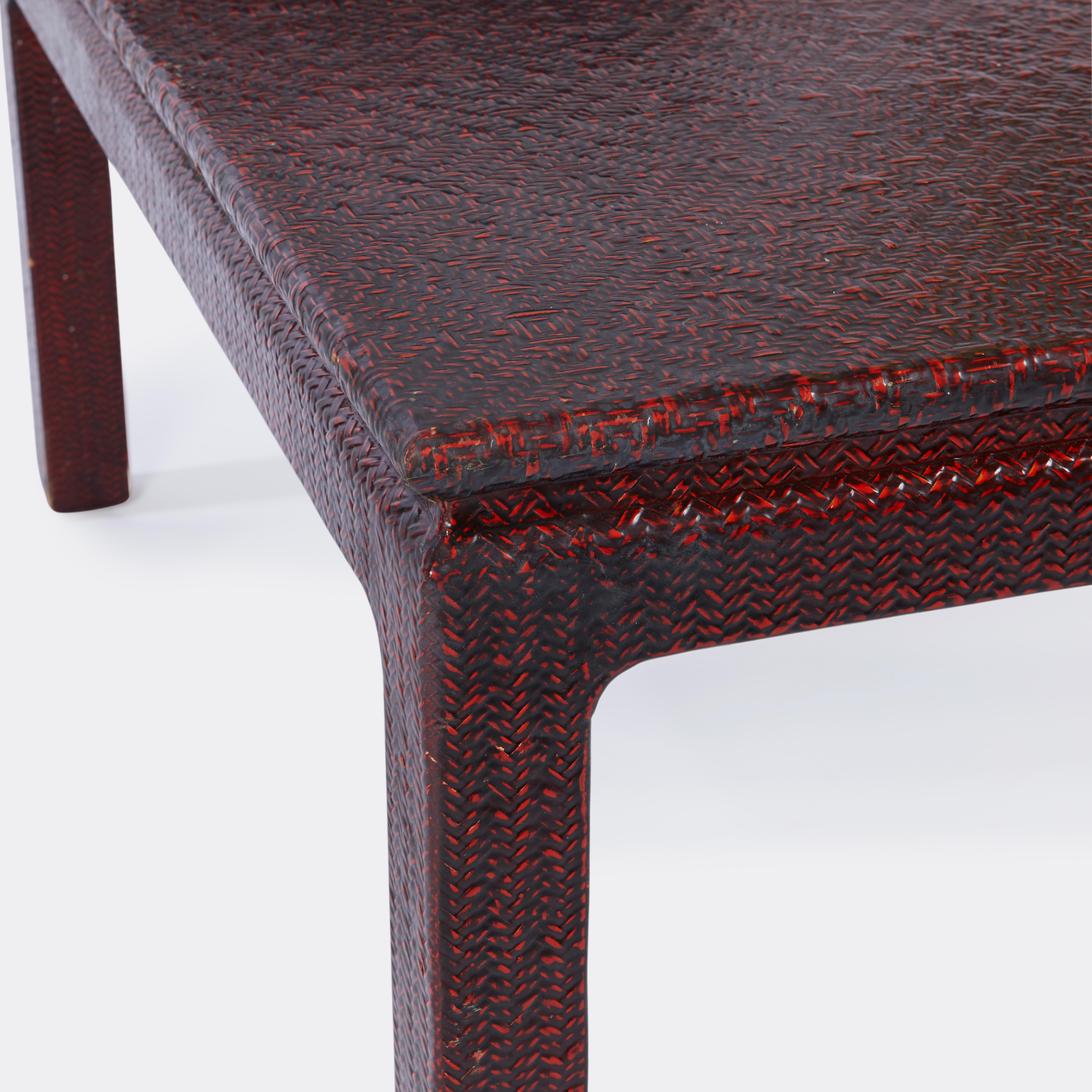 An American Karl Springer style red raffia lacquered coffee table with waterfall ends having red painted finish.