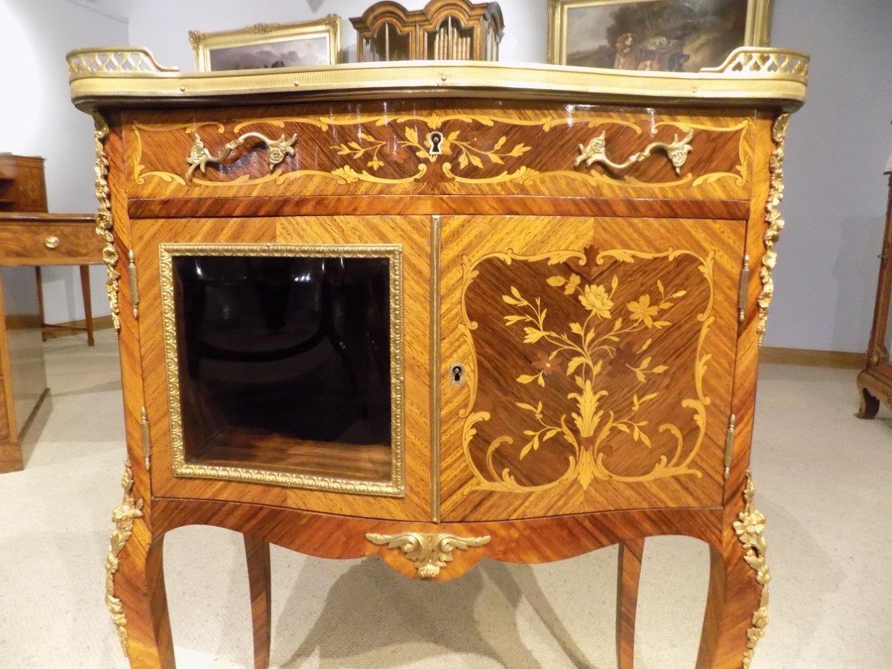 A Kingwood and Marquetry inlaid French side cabinet. The serpentine shaped top with a breche de lap marble top and a pierced ormolu gallery, above the serpentine mahogany lined drawer and cupboard with fine floral marquetry inlaid detail and a
