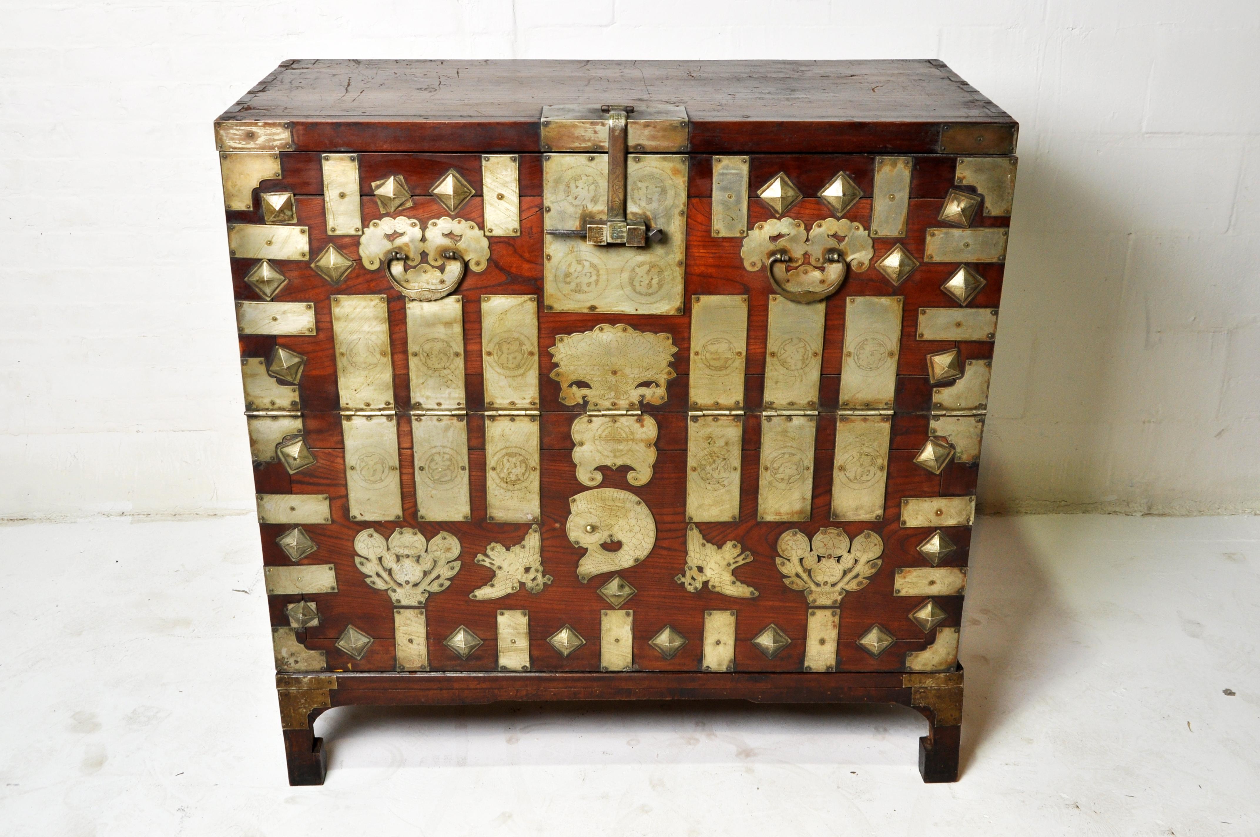 This brightly ornamented Korean chest was used to hold blankets, garments and other gifts that would be presented to the newlyweds as part of the dowry. It has a fall-front opening and large metal handles for carrying on either side. The elaborate