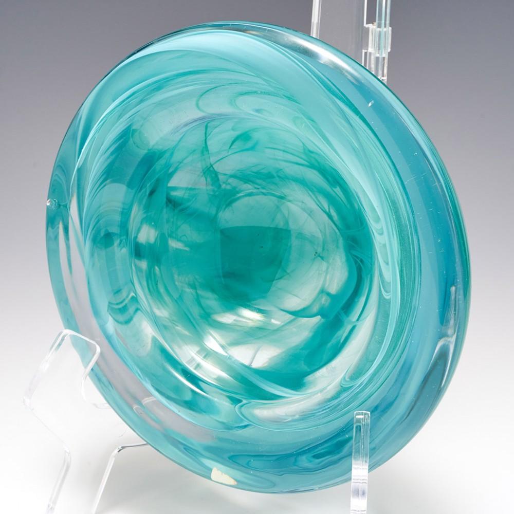 A Kosta Boda Bowl by Anna Ehrner, c1985

Additional information:
Date : 1981 to 1989
Origin : Kosta, Sweden
Bowl Features : Turquoise and blue smoke like swirls set within thick clear glass
Marks : Factory label
Type : Lead art glass
Size : H 8.4