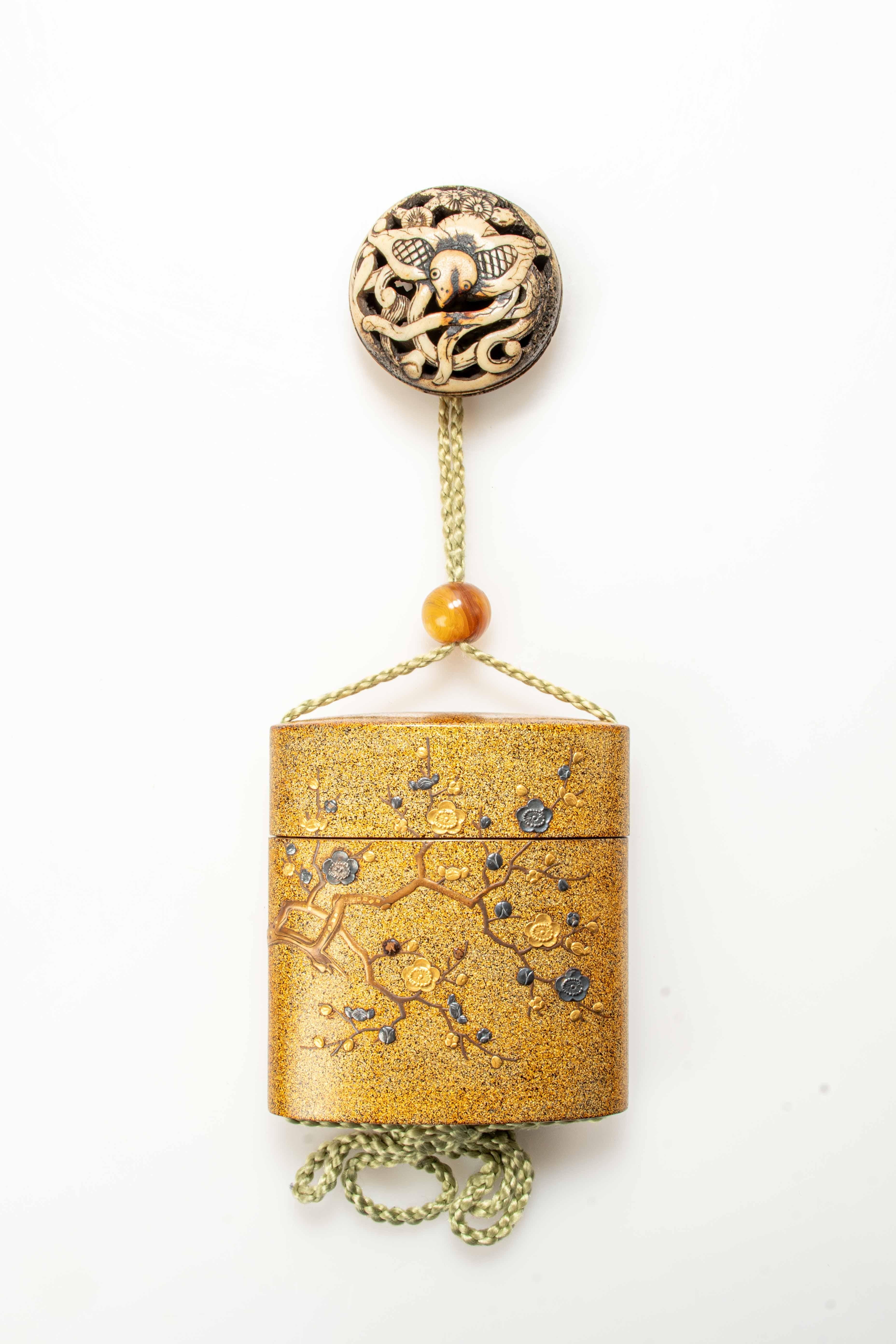 Inro in lacquer with applications of gilded and burnished metal flowers, depicting the blossoming of the cherry tree, on a nashiji background.

The decorative branches on the inro were created using the maki-è relief technique in lacquer. The ojime