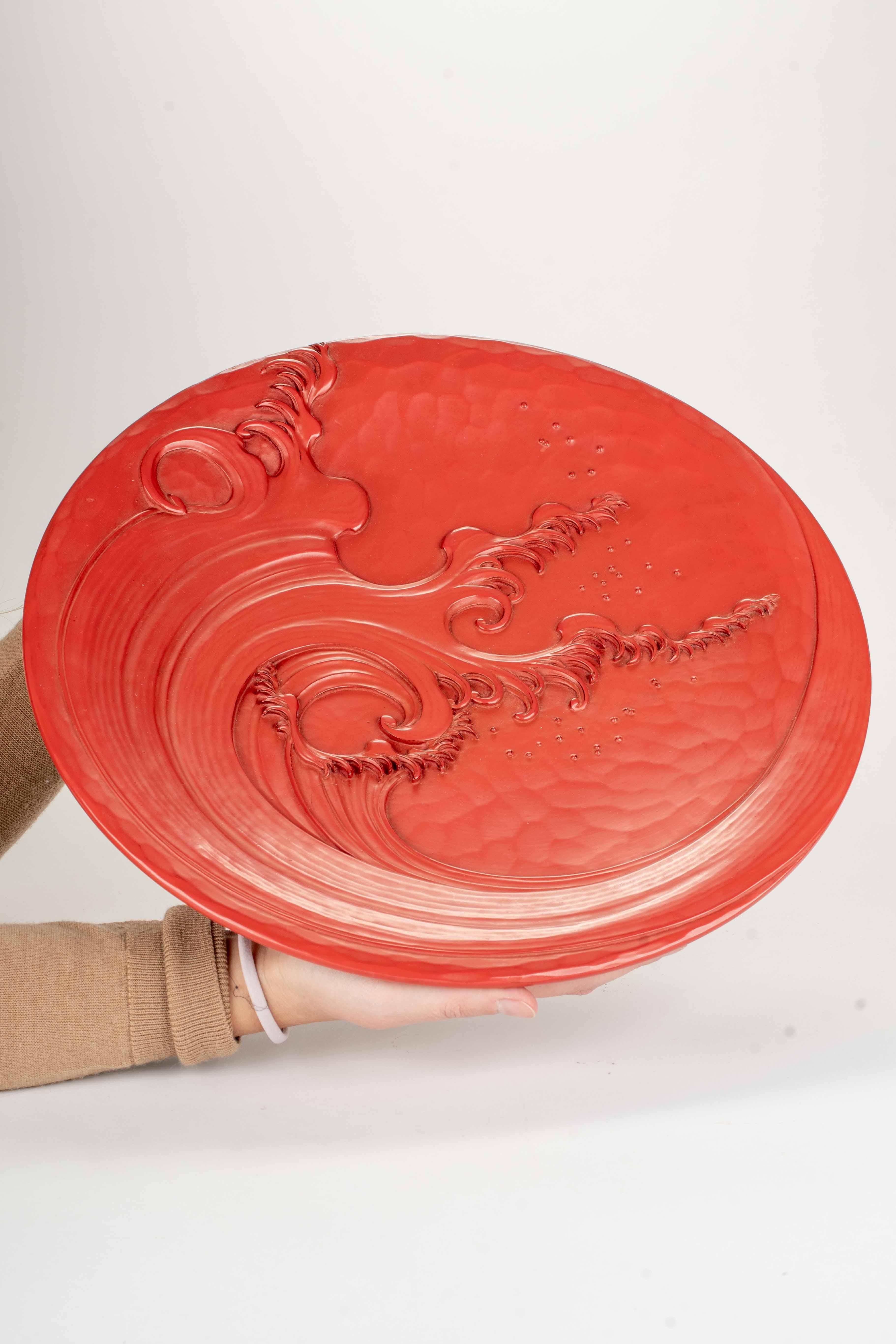 Hand-Crafted A lacquered wooden plate decorated in relief with a majestic wave