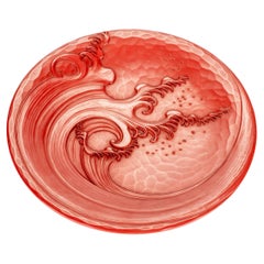 A lacquered wooden plate decorated in relief with a majestic wave