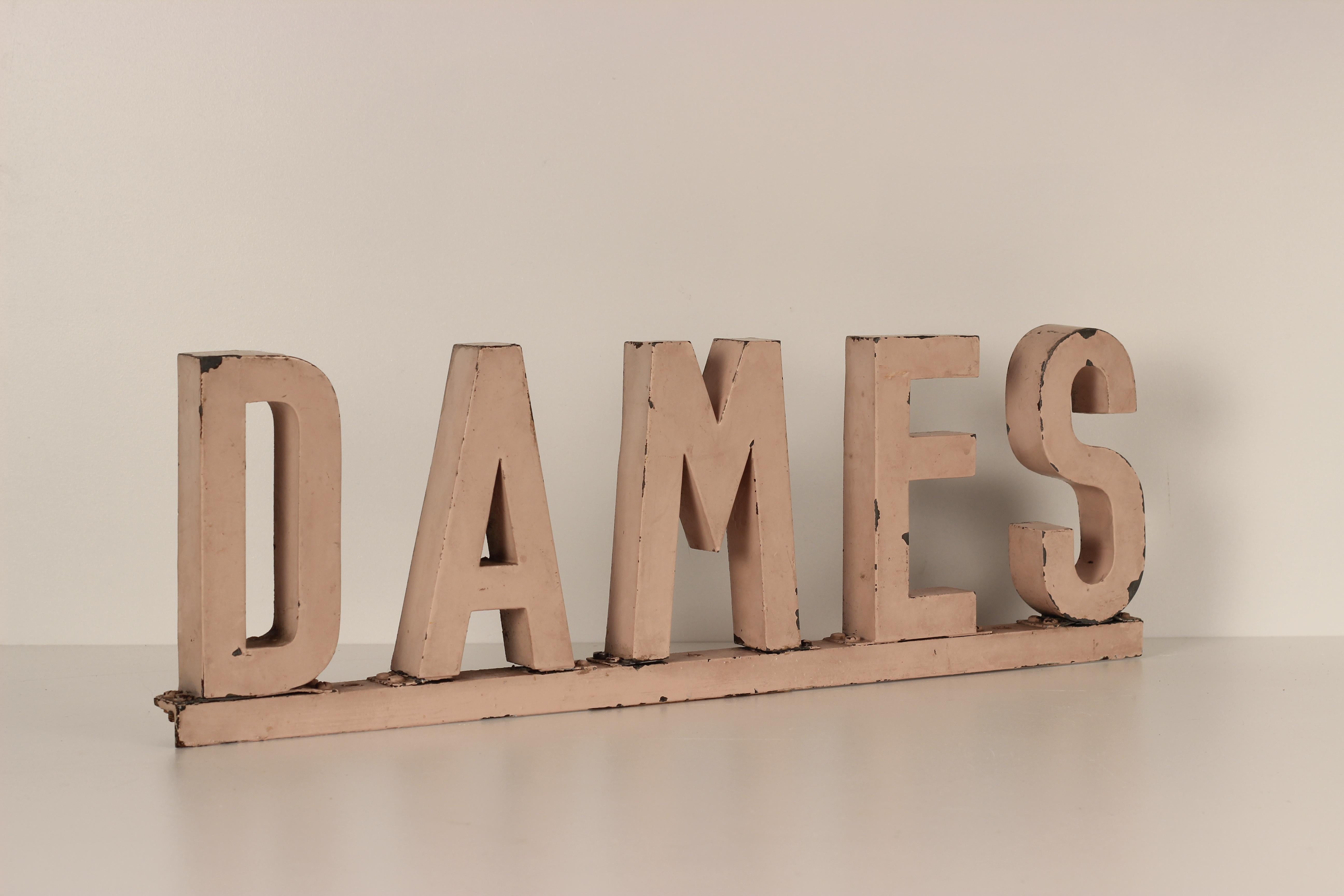 A French Mid Century Modern Swimming Pool changing room sign for a Lady or Ladies. The 3 dimensional letters made from metal box cut and riveted and welded on to a base plate in Original painted finish spell the word ‘Dame’.

General note: Shipping