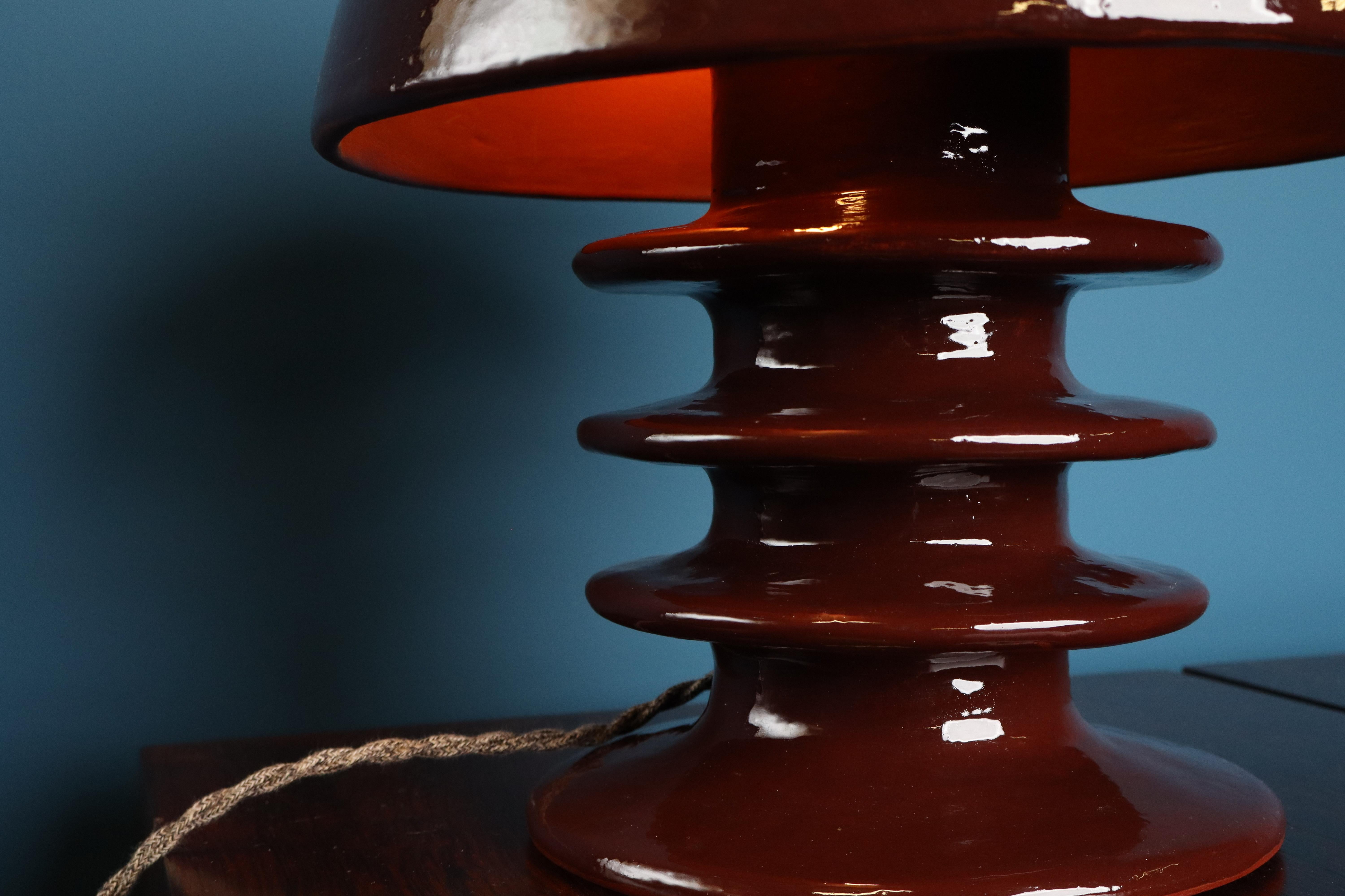 Esta elegante lámpara de mesa de la colección Pachamama de Mariela Cerámica tiene una pantalla de cerámica hecha a mano en Bélgica y acabada con un esmalte de tonos naturales. La pieza evoca una presencia tranquila y orgánica. Su superficie