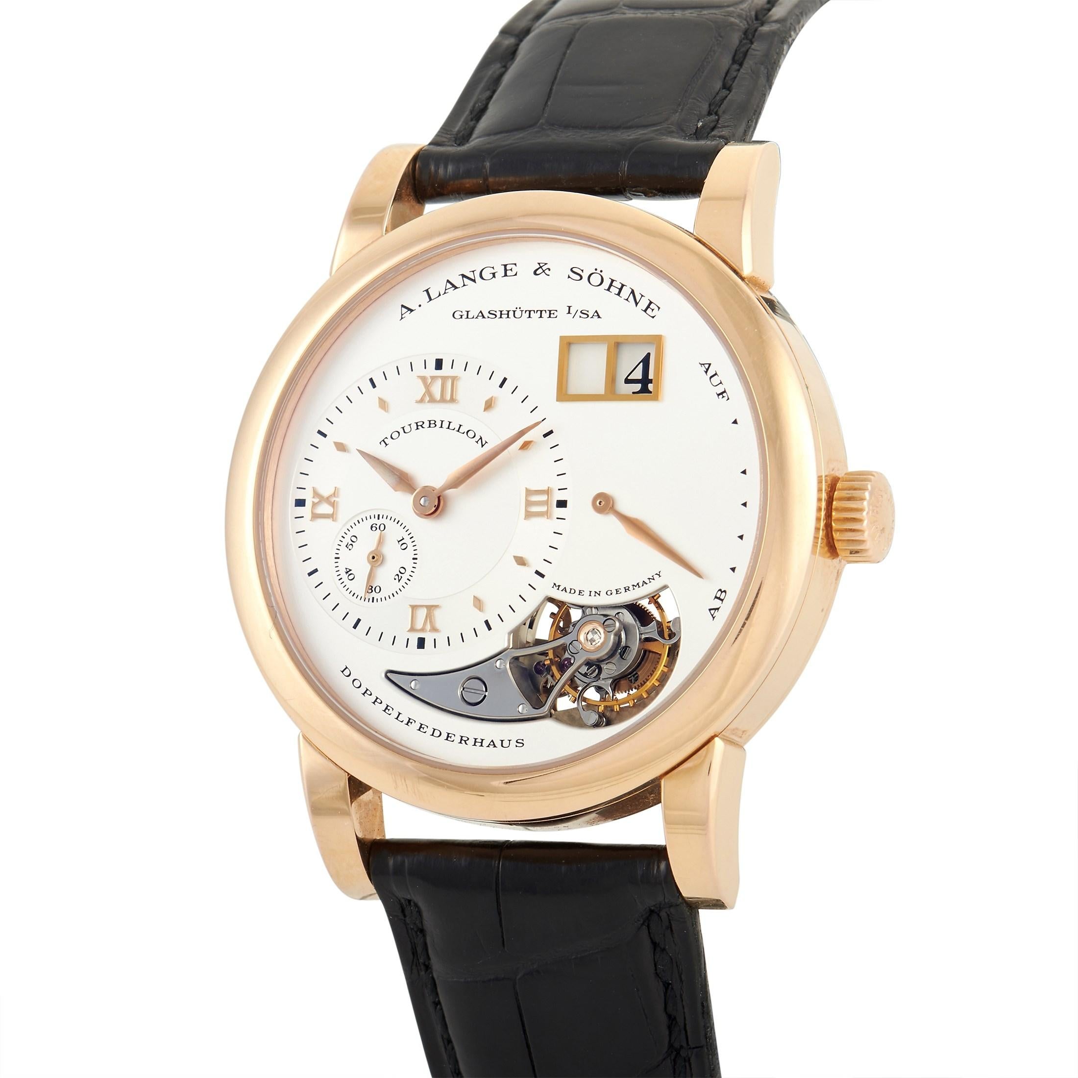 A limited edition timepiece, this Lange 1 Tourbillon 704.032 comes with an 18K rose gold case measuring 38.5mm in diameter. The three-body case, bezel, and curved lugs are all polished. It has a rhodium silver dial with 18K rose gold sword hands,