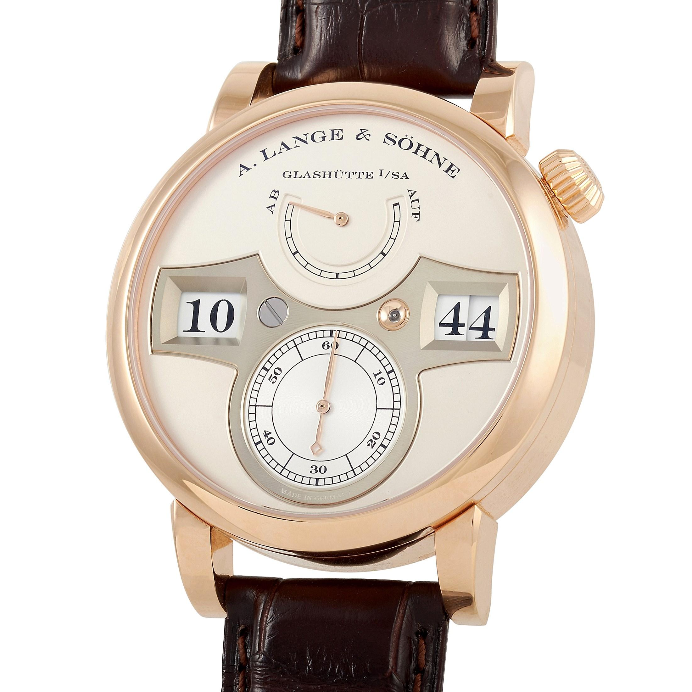 This A. Lange & Sohne Zeitwerk 41.9 mm Rose Gold Watch, reference number 140.032, has an 18K rose gold case that measures 41.9 mm in diameter. The case is presented on a deep brown alligator leather strap with tang closure. The open case back offers