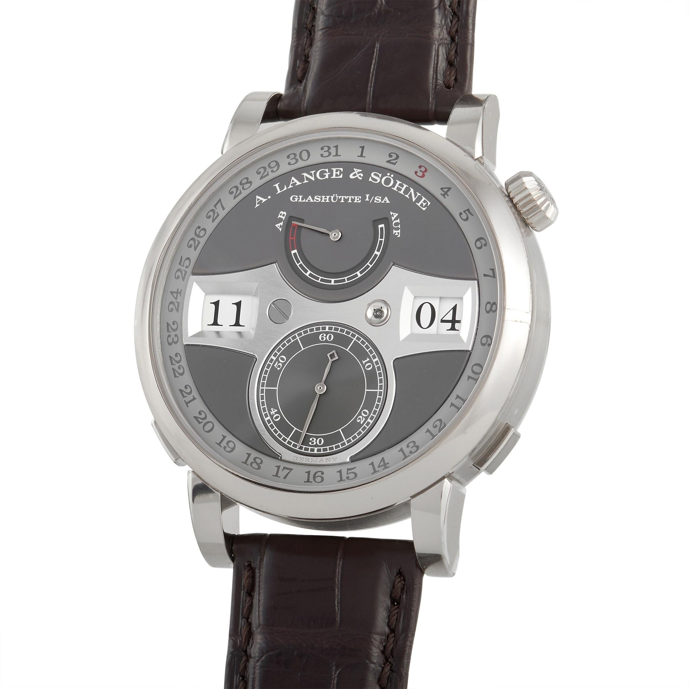 The A Lange & Sohne Zeitwerk Date Watch, reference number 148.038, provides a fresh, contemporary take on a classic timepiece. 

Attached to a brown leather strap, you’ll find a 44mm case crafted from 18K White Gold. On the light gray dial, you’ll