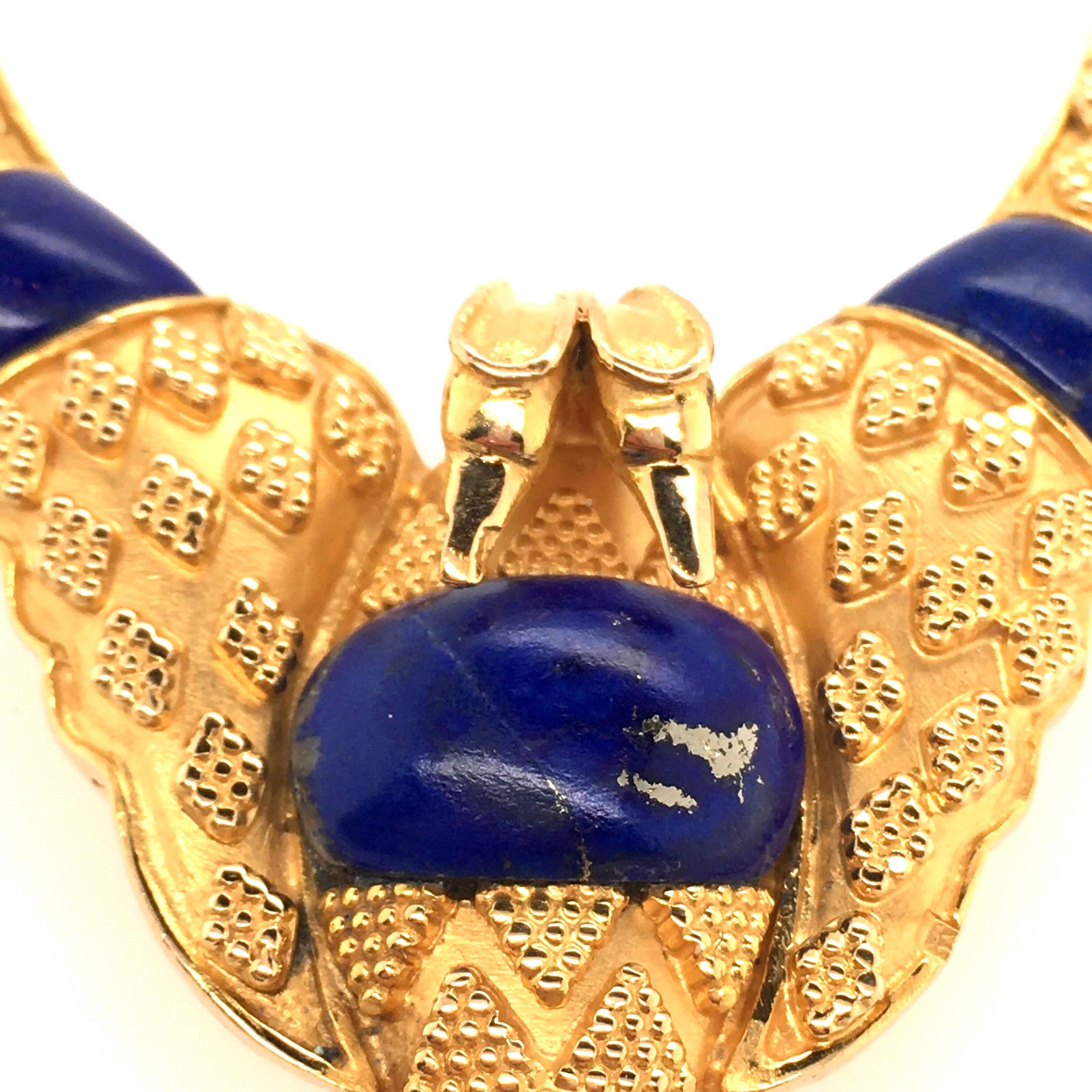 An 18 karat yellow gold and lapis lazuli double headed eagle brooch. Decorated with granulation, set with lapis lazuli panels. The brooch measures approximately 2 x 1/3/4 inches, gross weight is approximately 26.7 grams. 